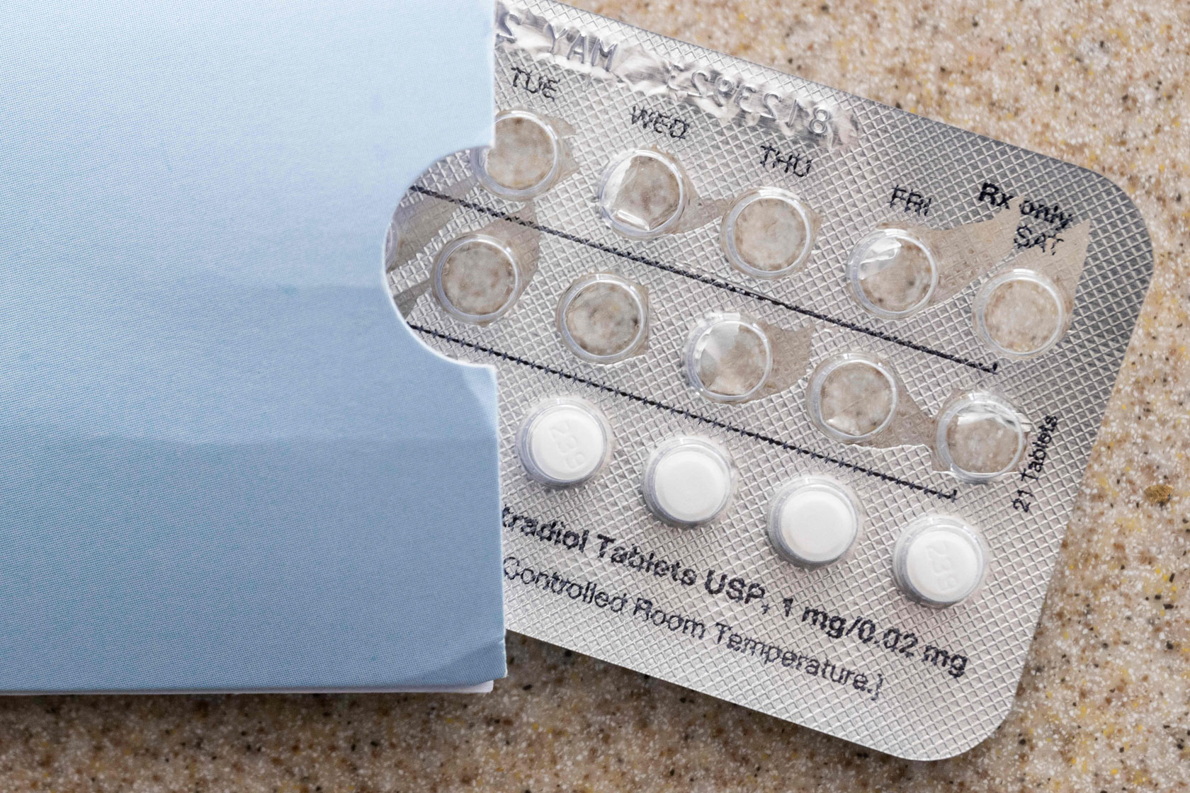 A mostly used birth control packet rests on a counter top.