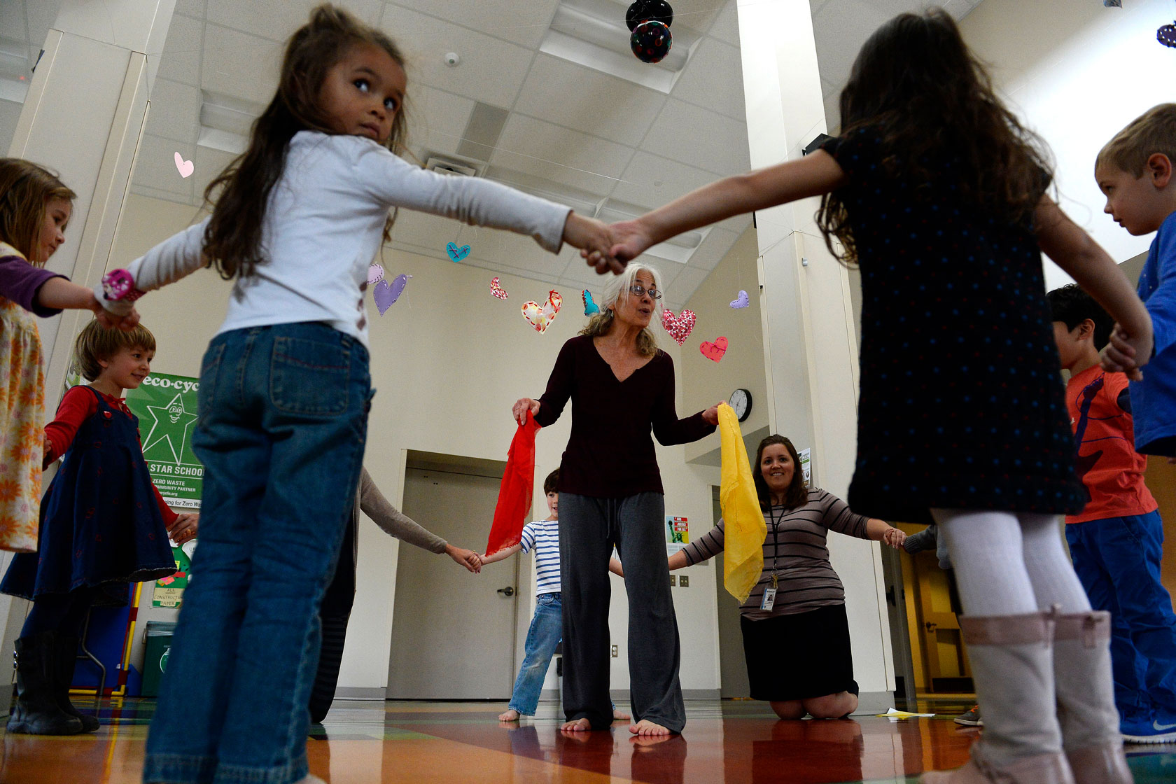 A teacher surrounded by her students leads preschoolers in dance during a class at an early childhood center in Boulder, Colorado.