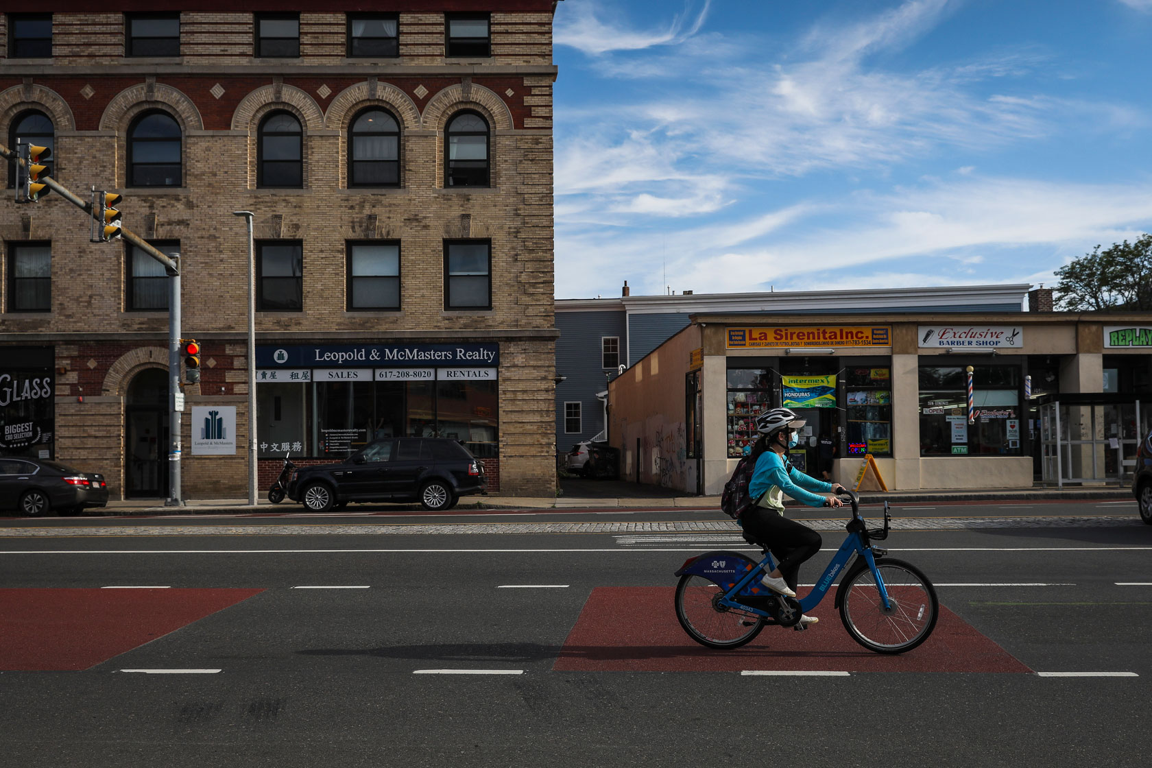 A woman on a bike passes through an intersection in a Boston neighborhood.