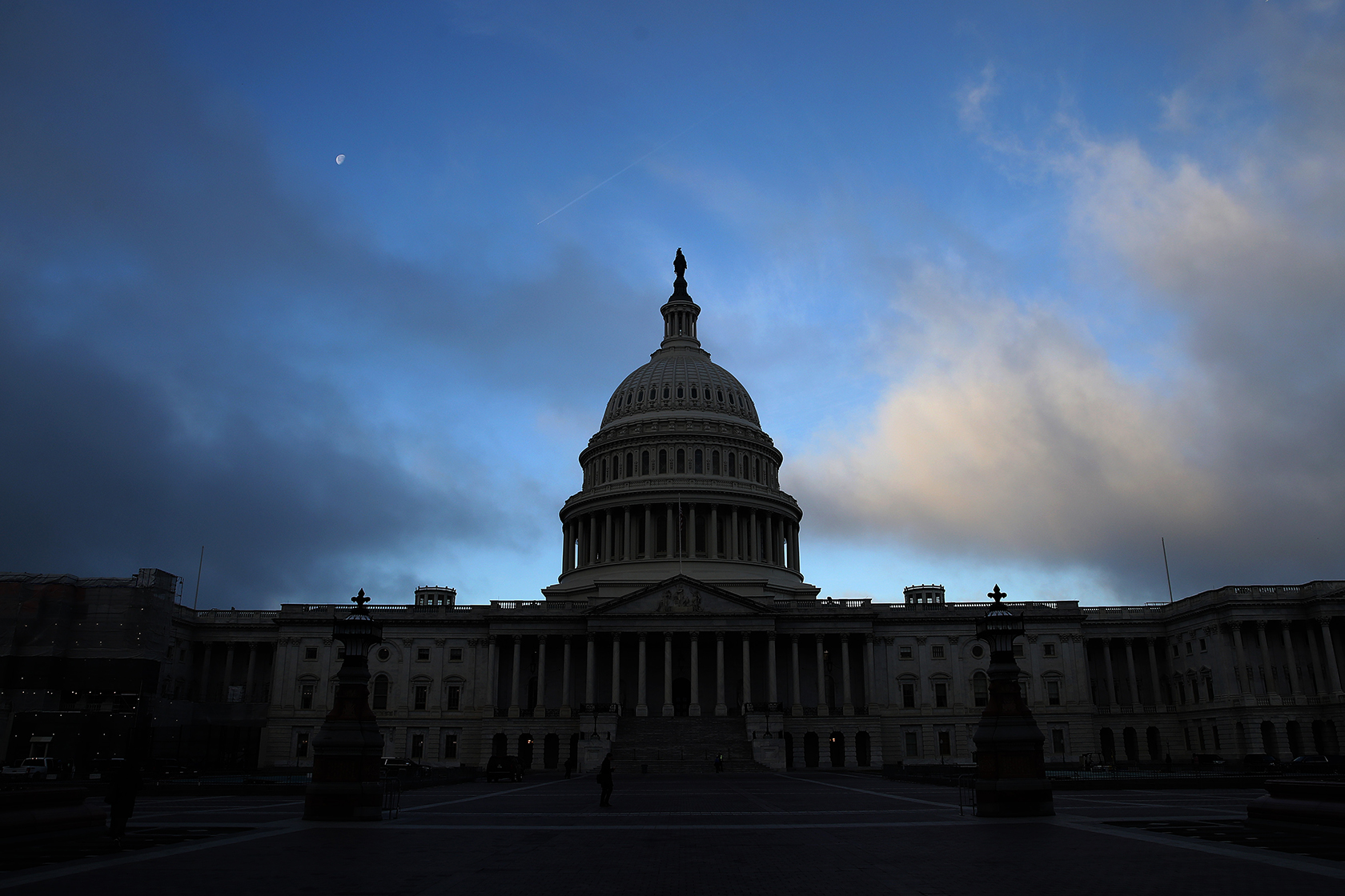 U.S. Capitol exterior as moon is still visible in sky