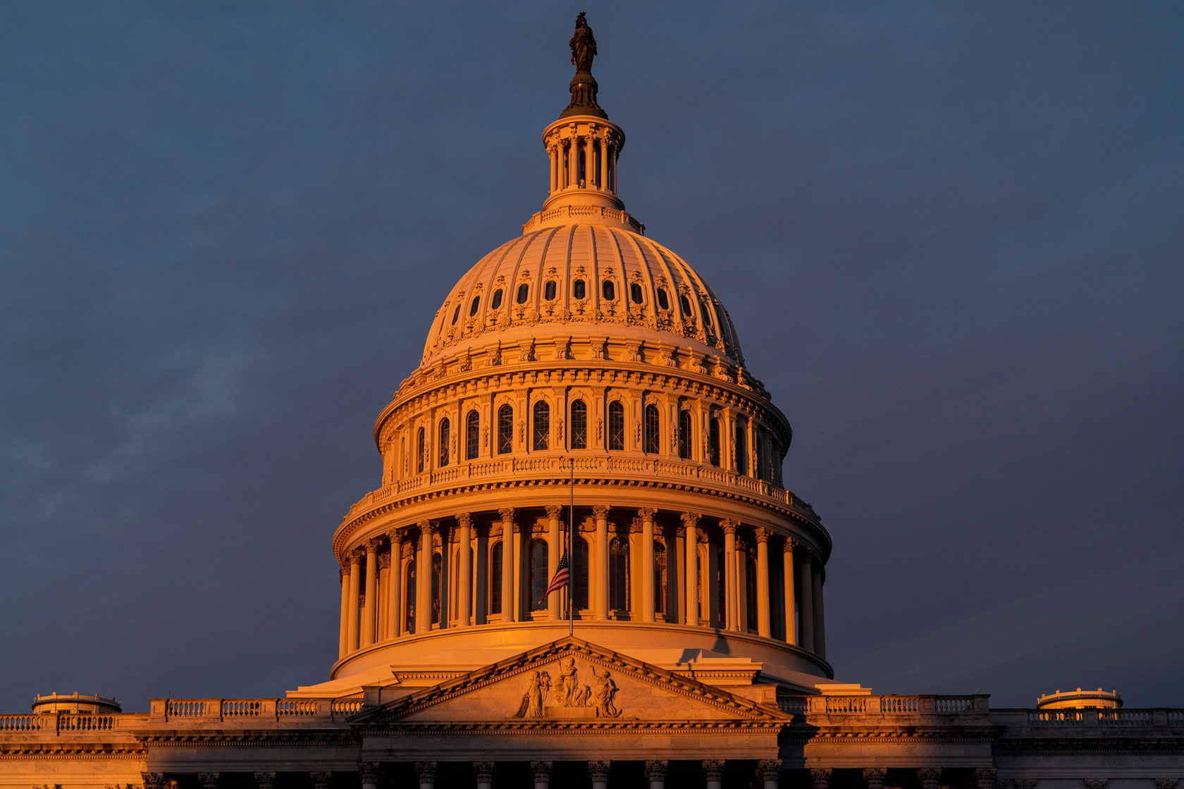 The dome of the U.S. Capitol Building is illuminated by the rising sun on Capitol Hill.