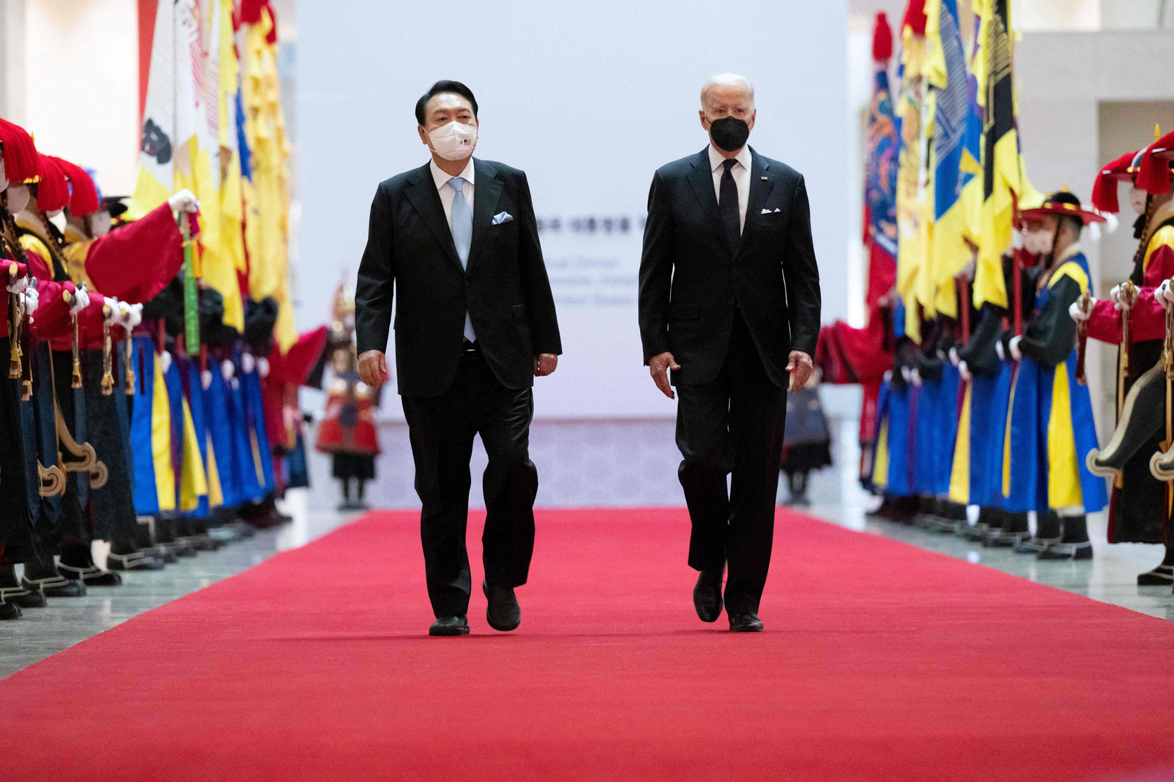 South Korean President Yoon Suk-yeol and U.S. President Joe Biden walk together as they arrive for a state dinner in South Korea.