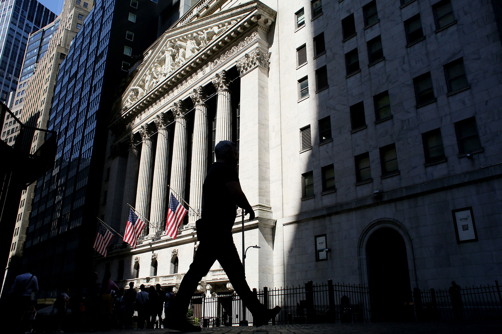 People walk past the New York Stock Exchange.