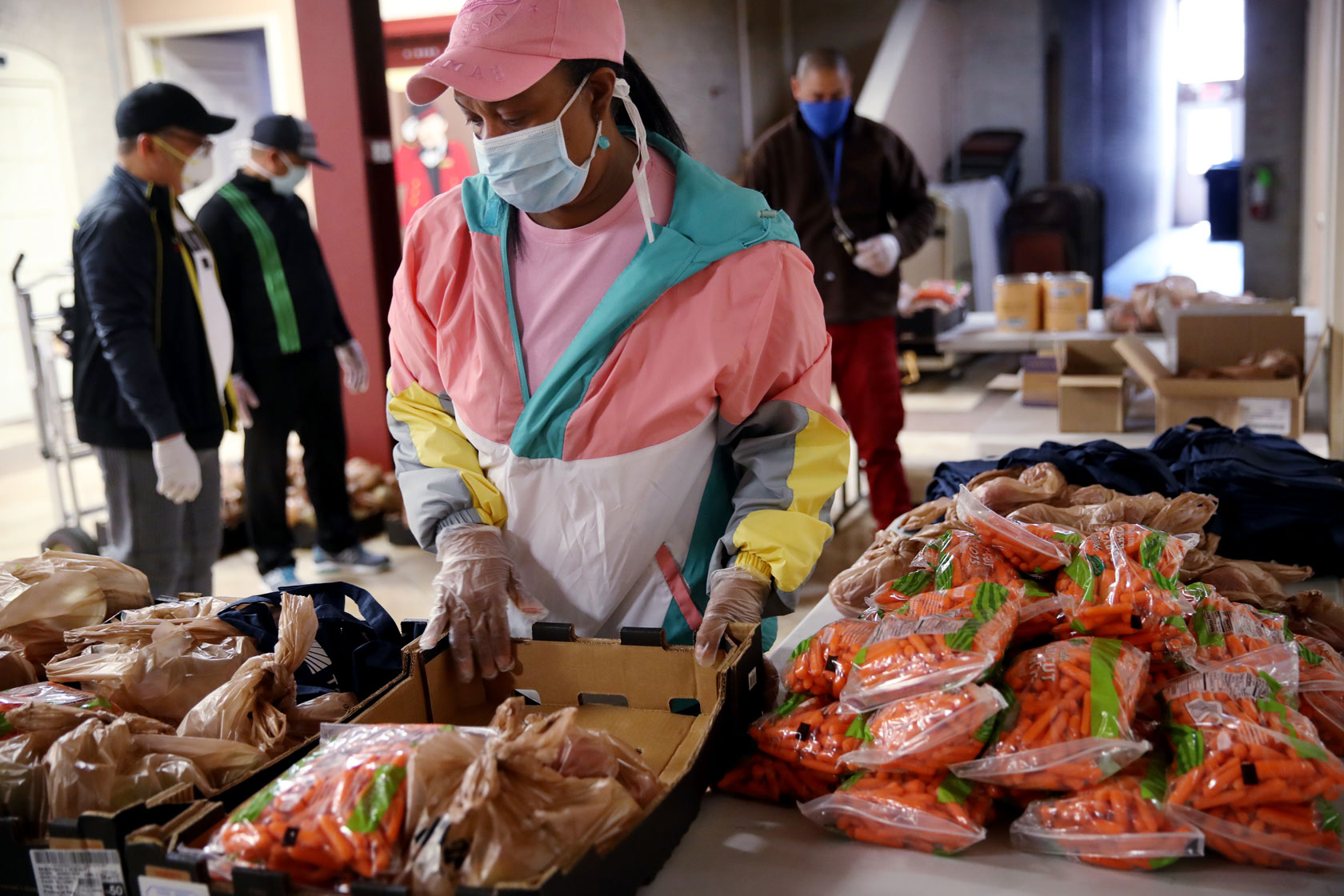 A pastor organizes bags of carrots for delivery to those in need.