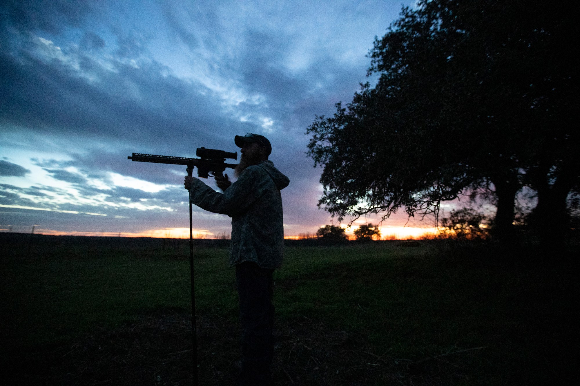 A man peers through the scope on his rifle in rural Texas.