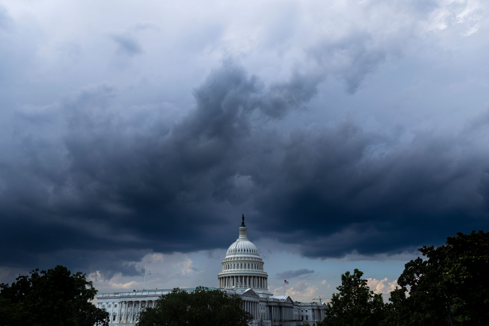 Photo shows the U.S. Capitol building against a dark, stormy sky