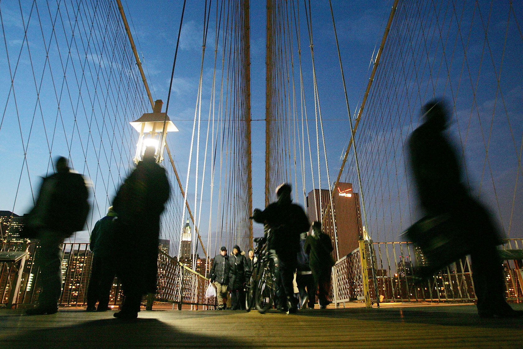 People walk across the Brooklyn Bridge