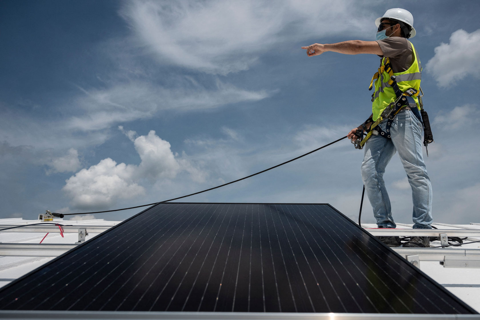 An employee with Ipsun Solar installs solar panels.