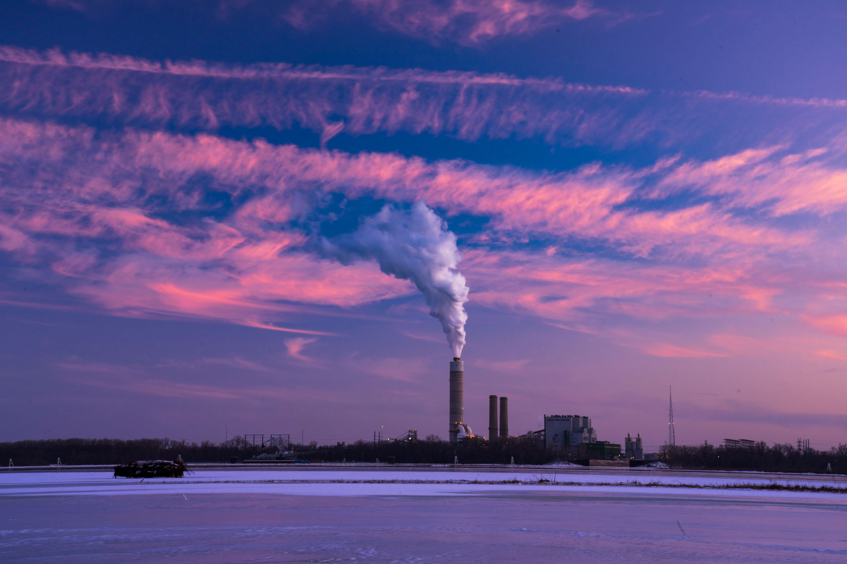 Smoke billows from a power plant across the Mississippi River.