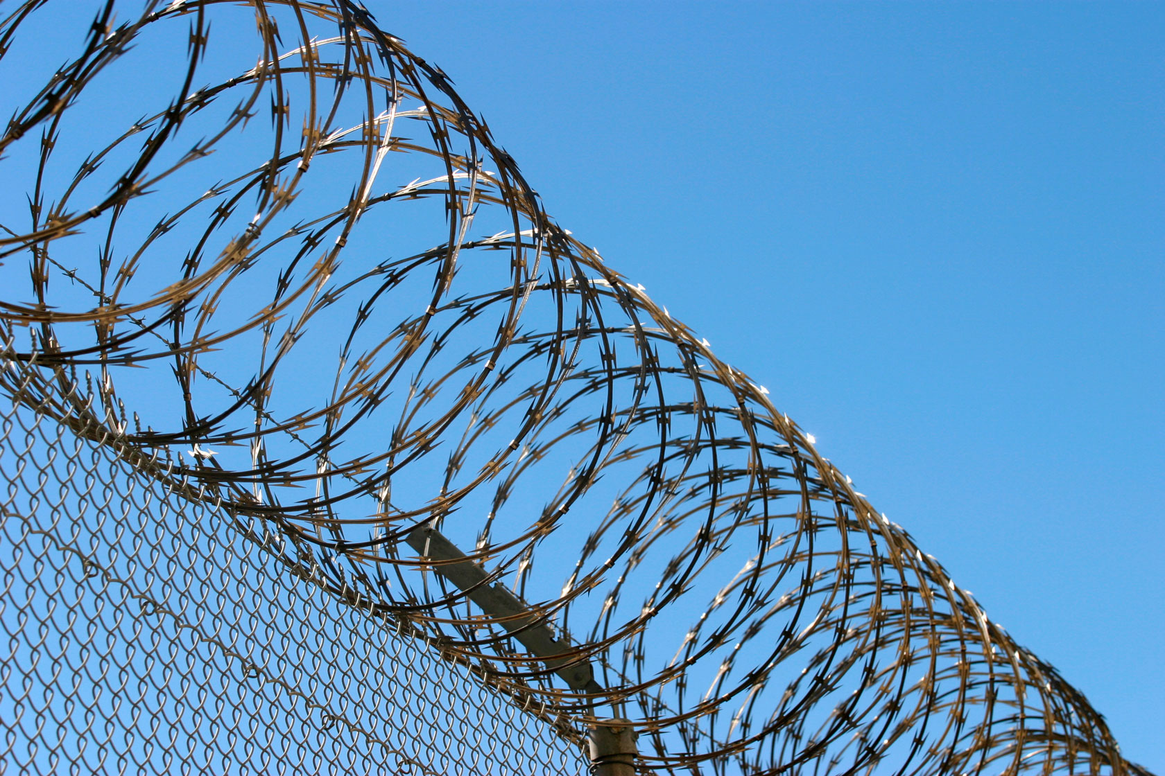 Photo showing razor wire outside of a prison