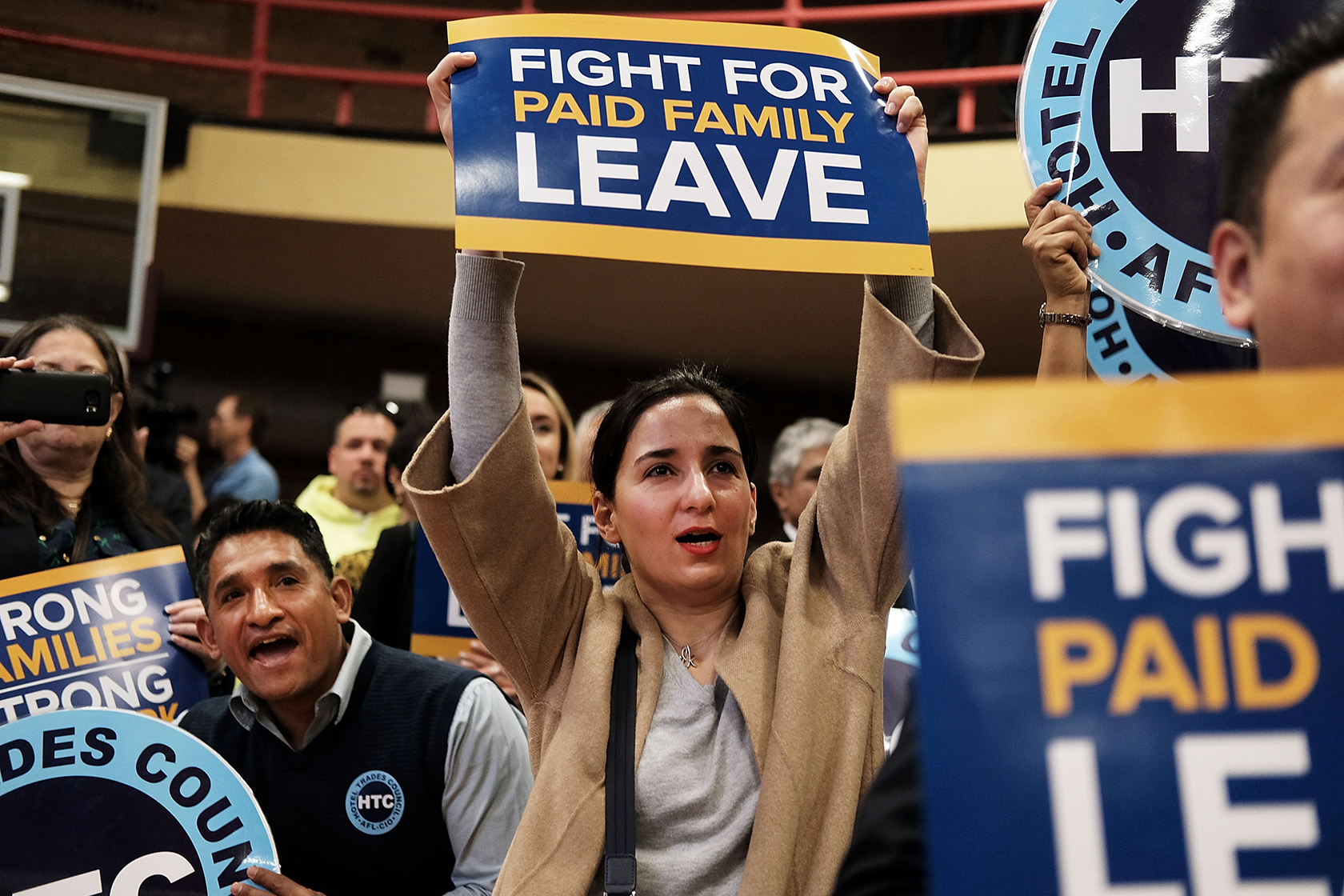 Person holding sign that says Fight for Paid Leave