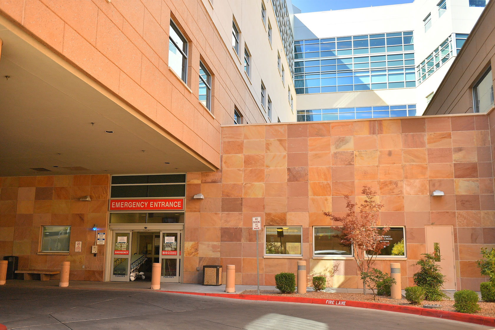 Photo shows an exterior view of a tan-colored hospital