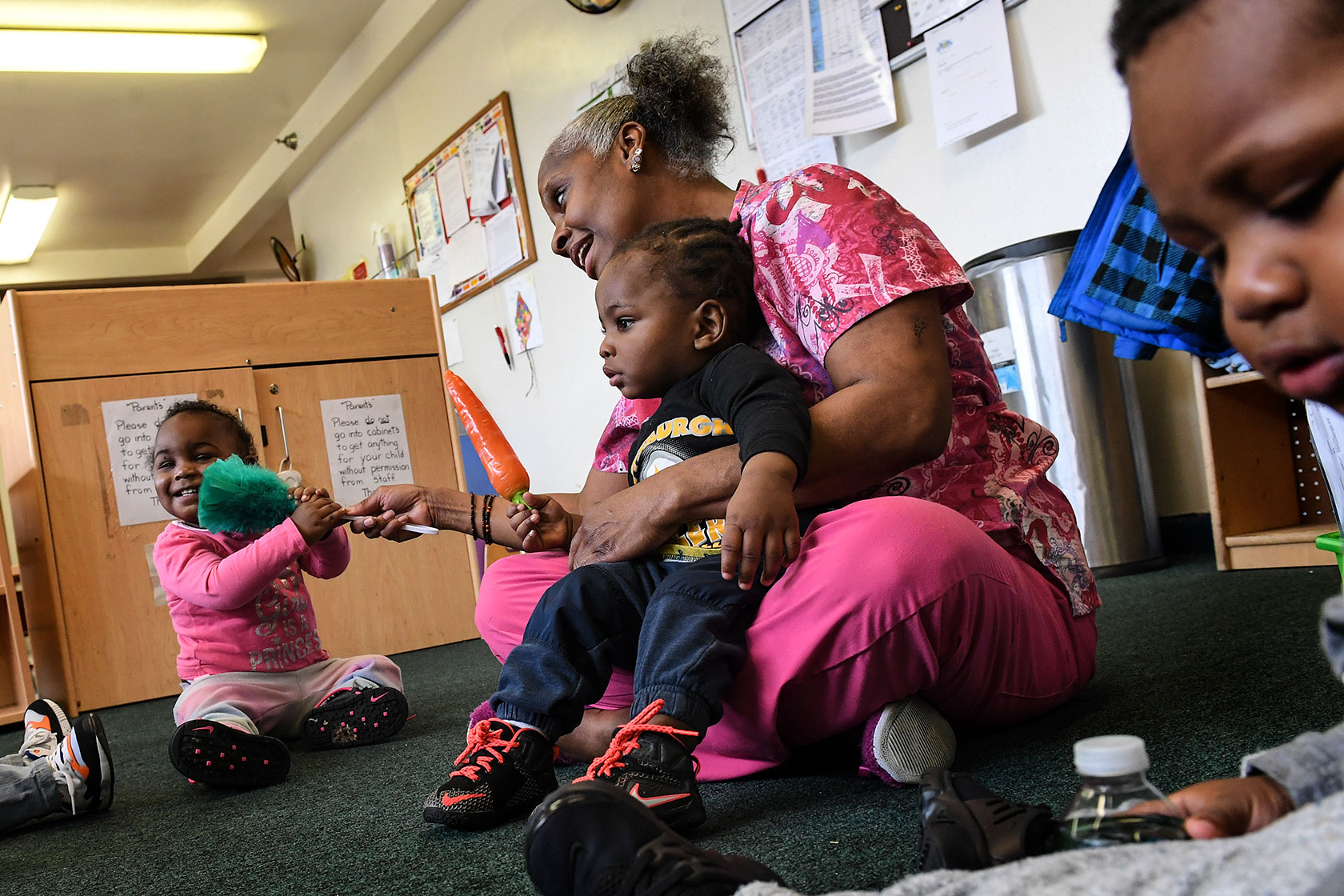 A child care worker engages children during an activity.