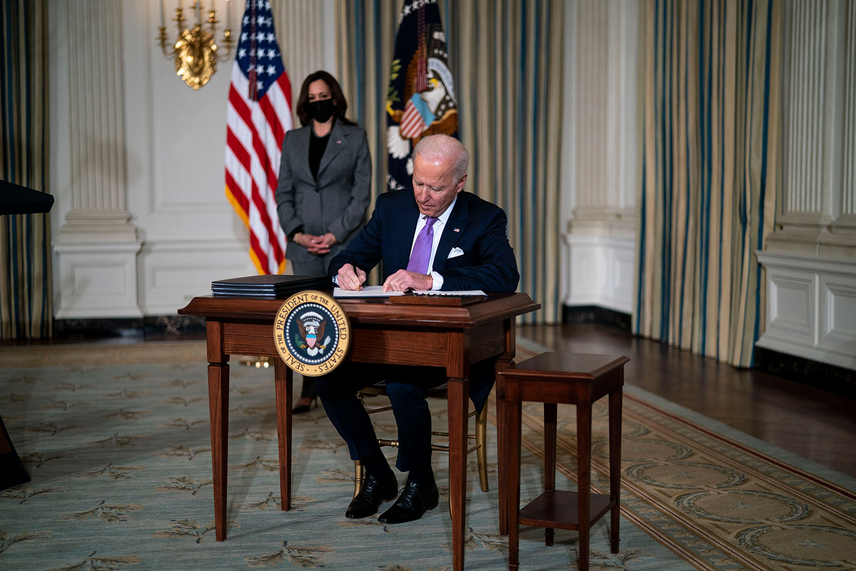 Vice President Kamala Harris looks on as U.S. President Joe Biden signs executives orders related to his racial equity agenda.