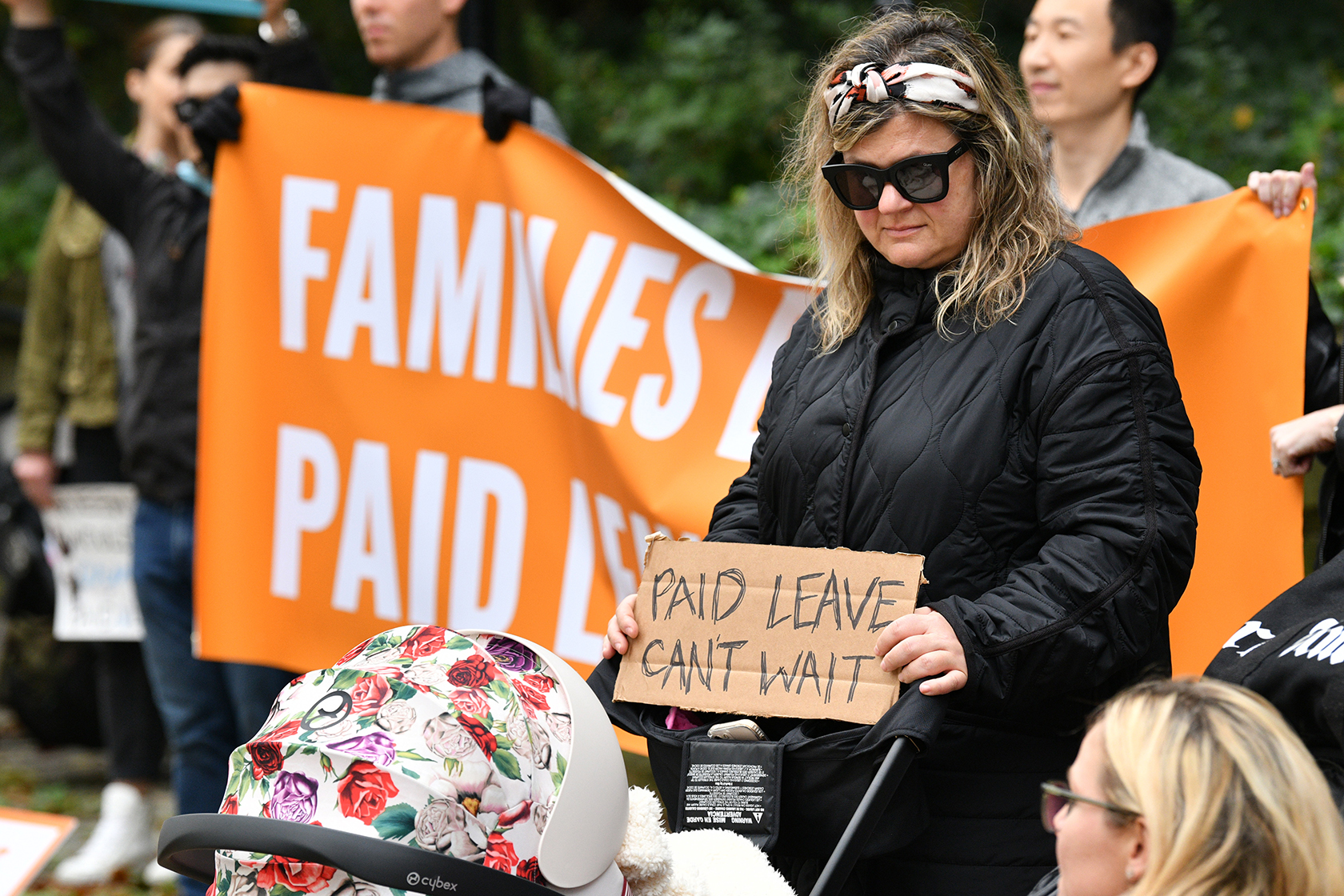Woman holding sign reading