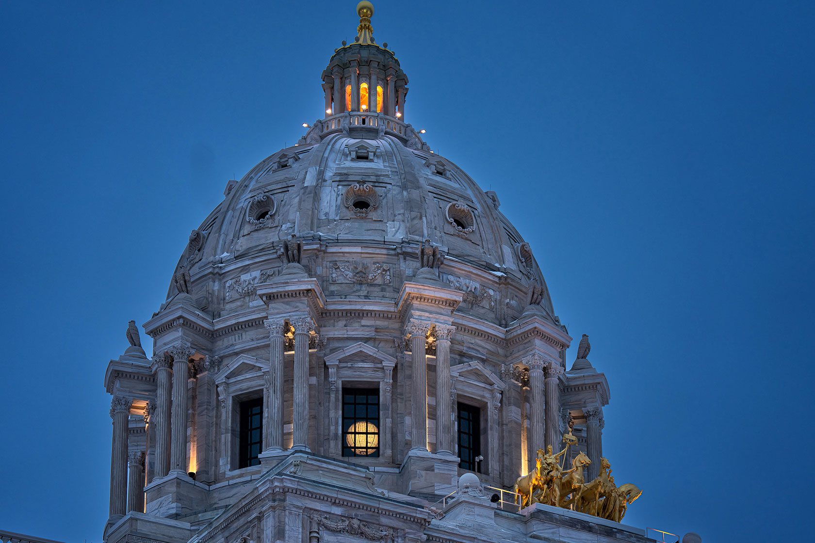 Photo shows the Minnesota state capitol dome against a dark blue sky