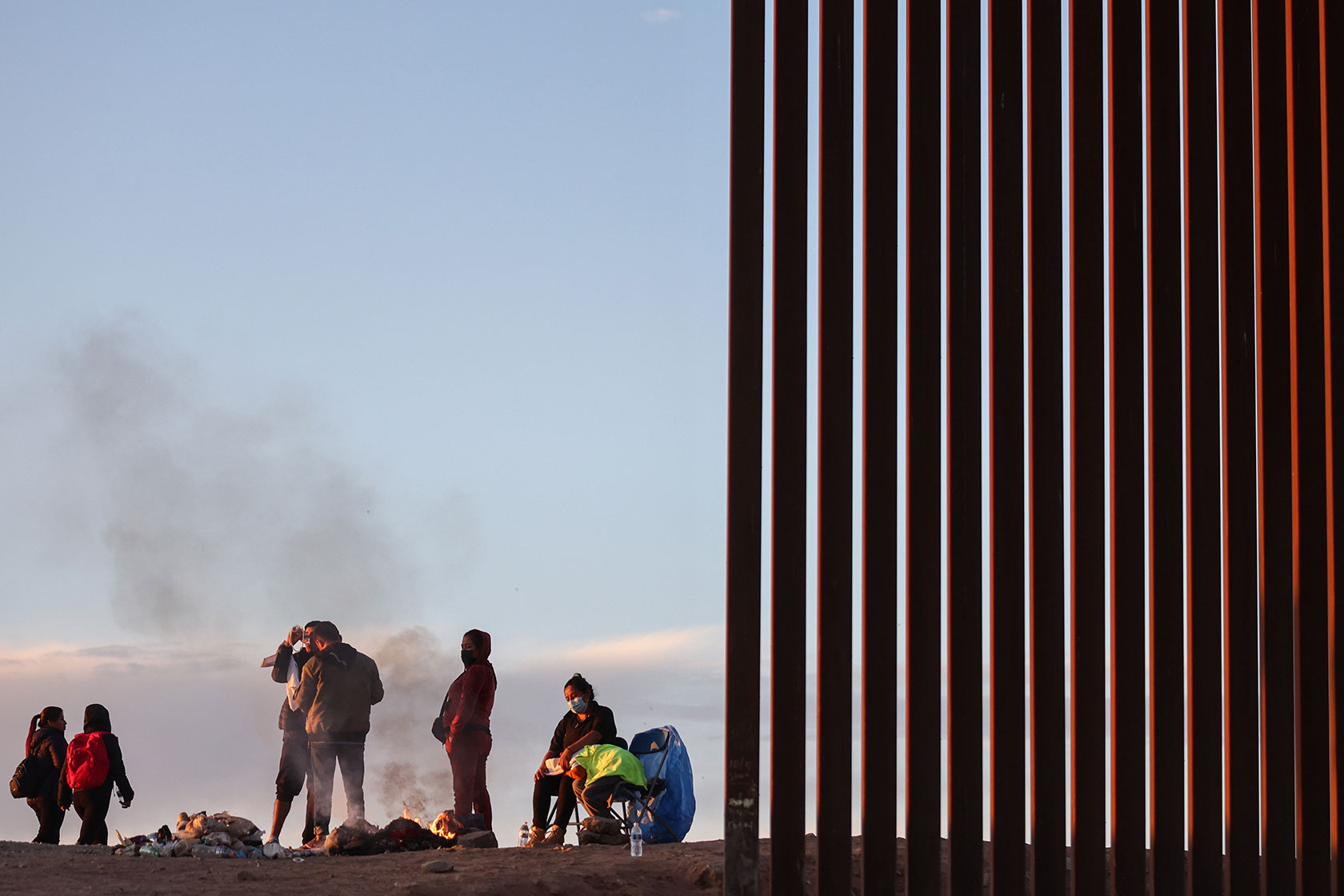 A group of immigrants warms themselves near the U.S.-Mexico border.