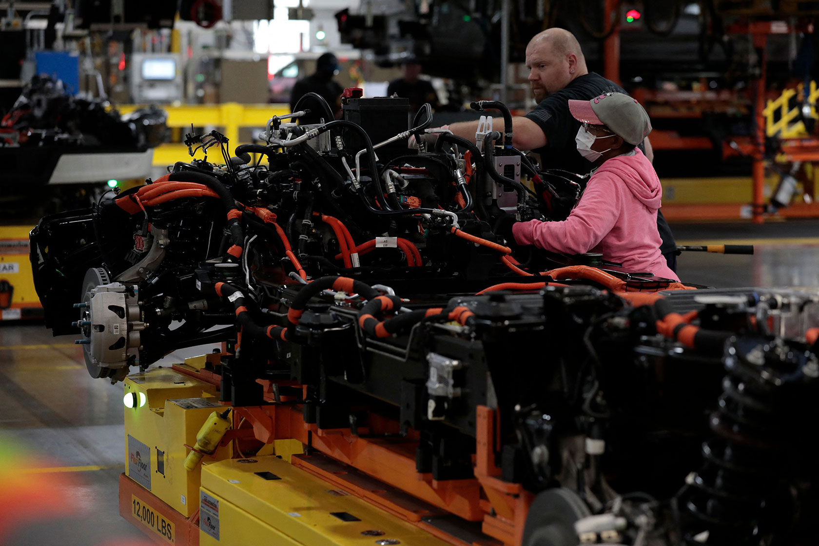 Photo shows two people assembling a piece of machinery