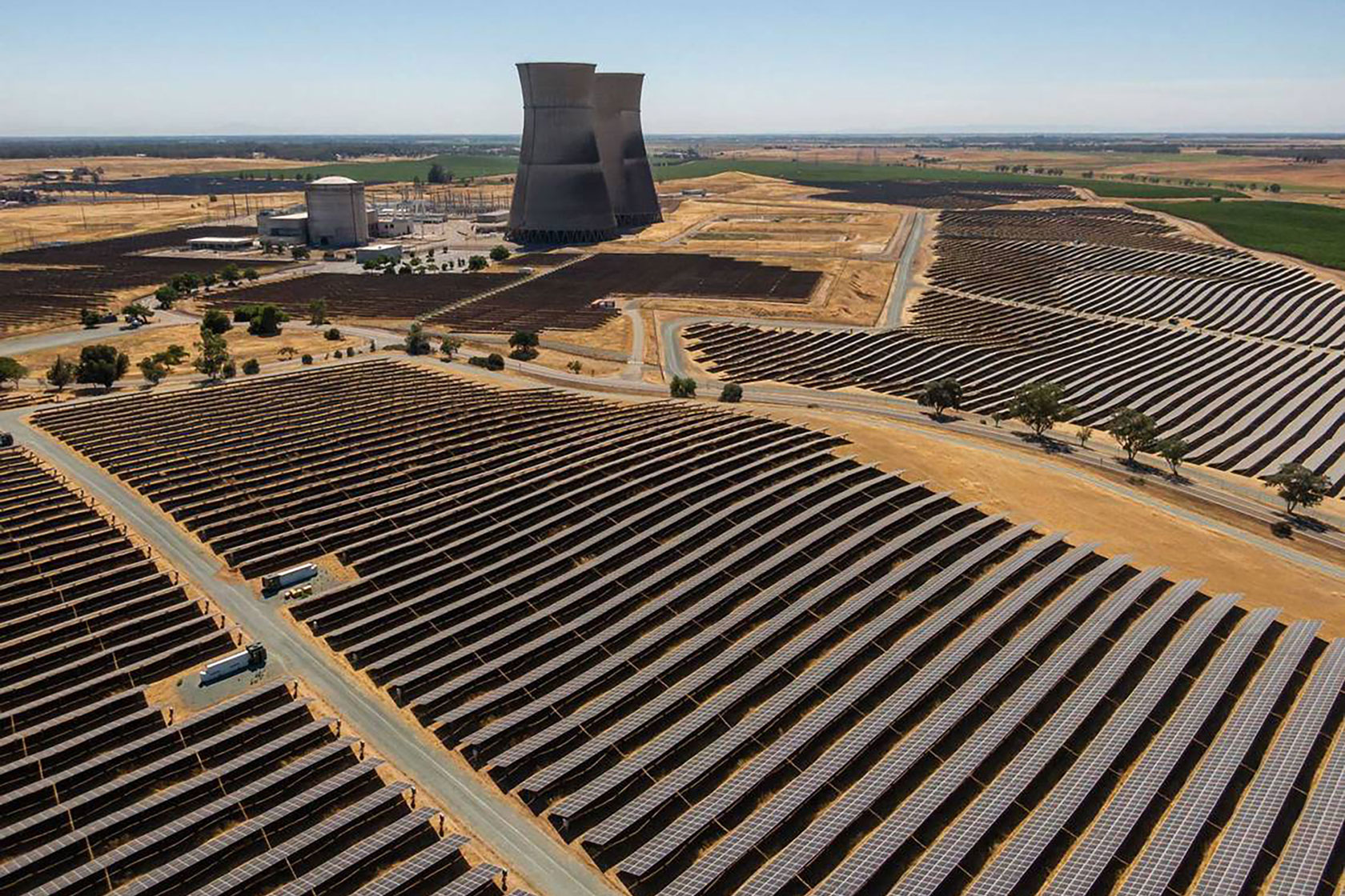 Photo shows a giant solar farm on dry ground on a sunny day