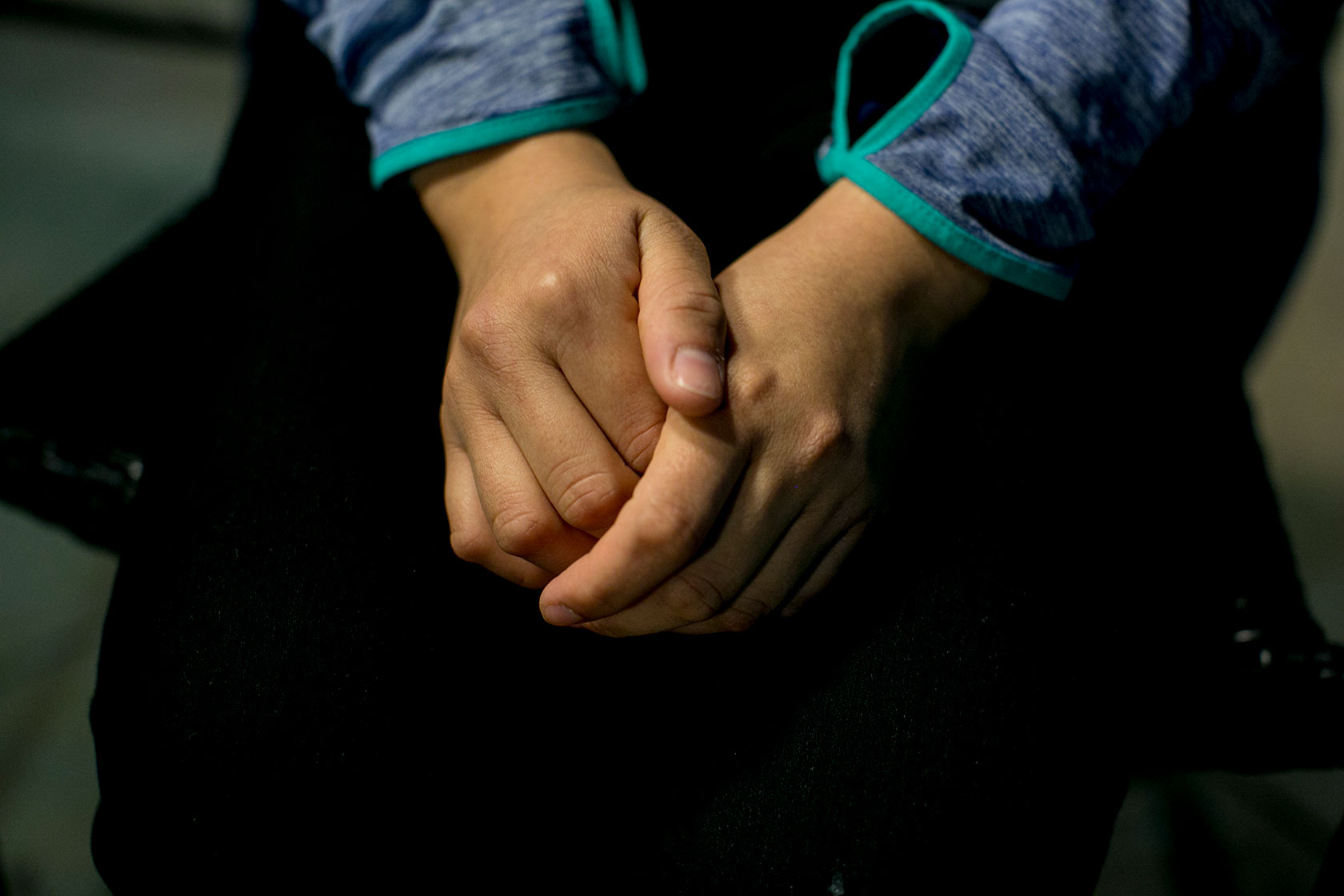 Photo shows a closeup of a woman's hands, with one clasped around the other