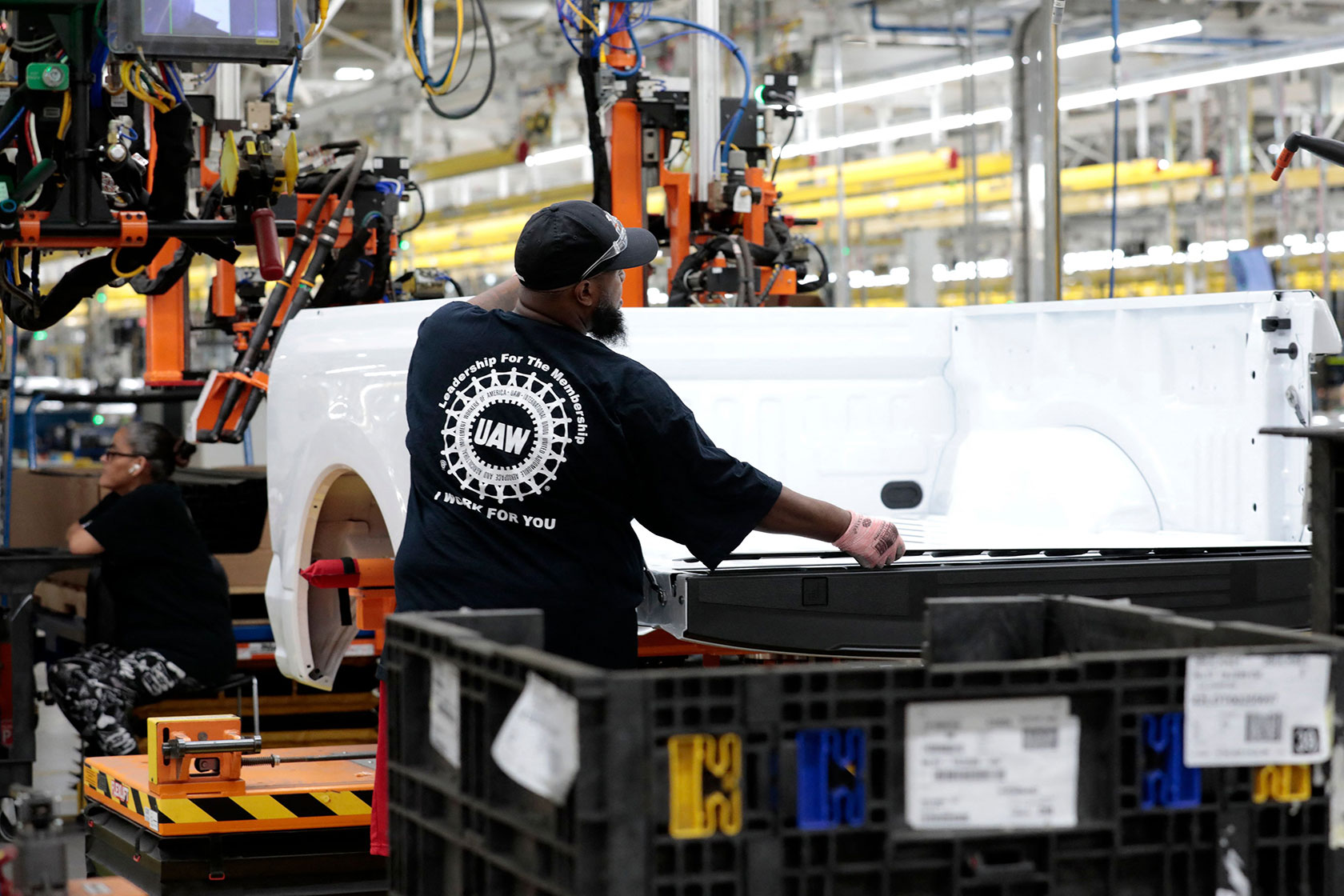 A worker works on the bed of one of Ford’s battery-powered F-150 Lightning trucks.