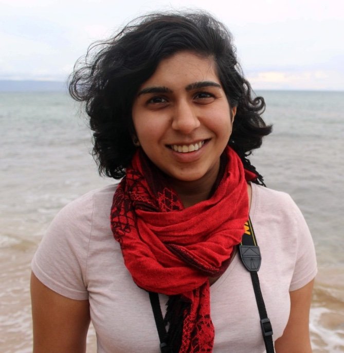 Ria Chakrabarty headshot. She is smiling, wearing a red scarf and has shoulder-length dark hair.