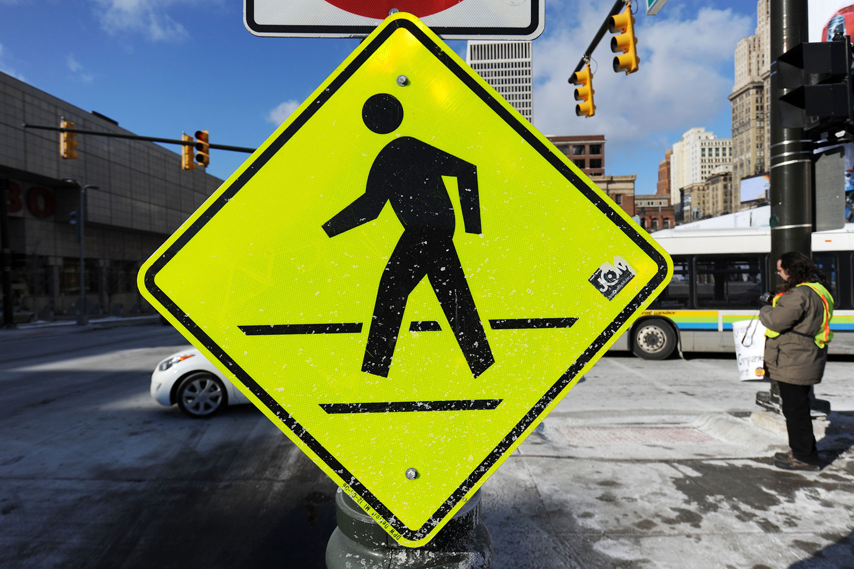 Photo centers a diamond-shaped bright-yellow sign indicating a pedestrian walkway