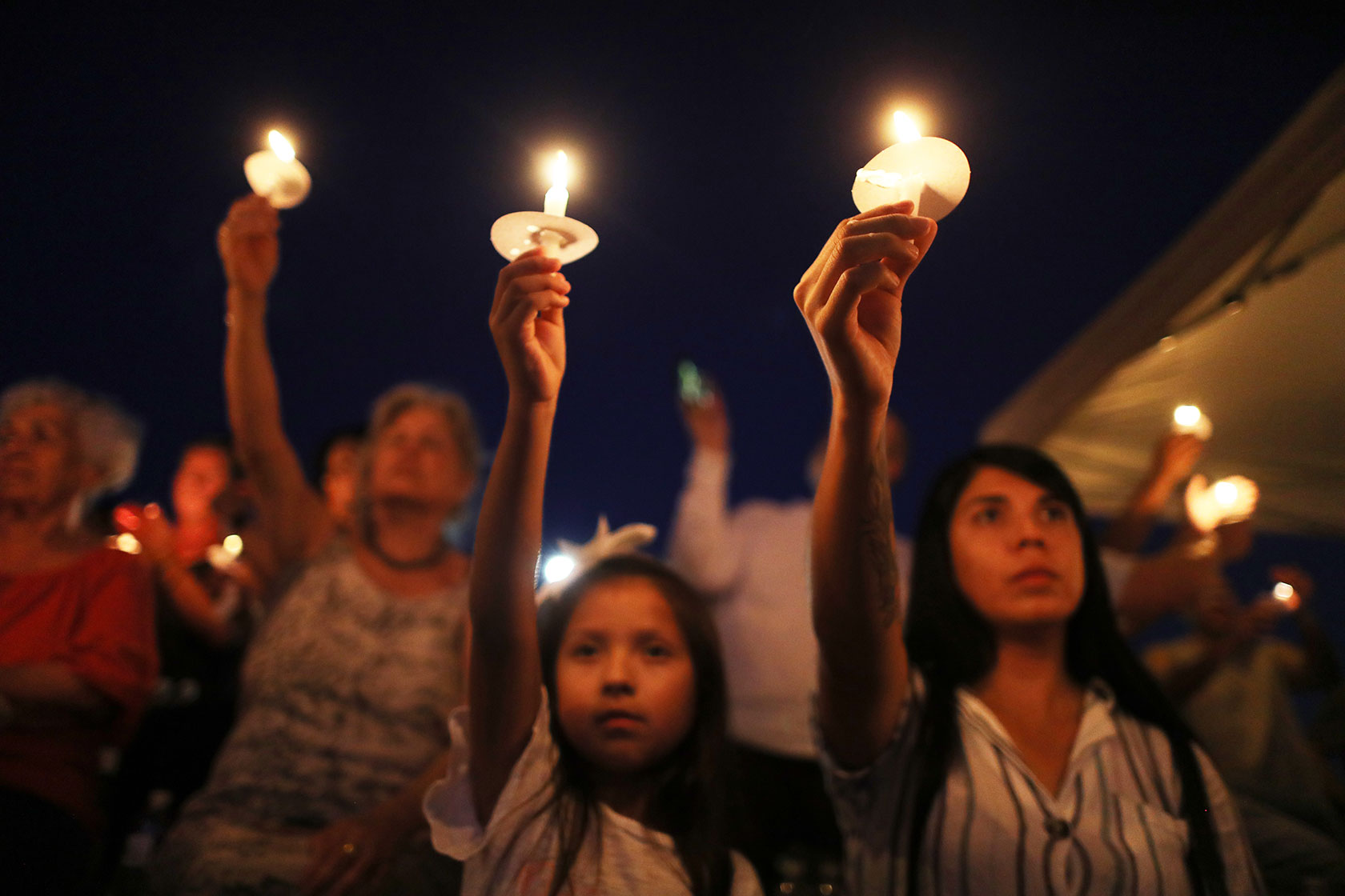 People attend a candlelight prayer vigil outside Immanuel Church .