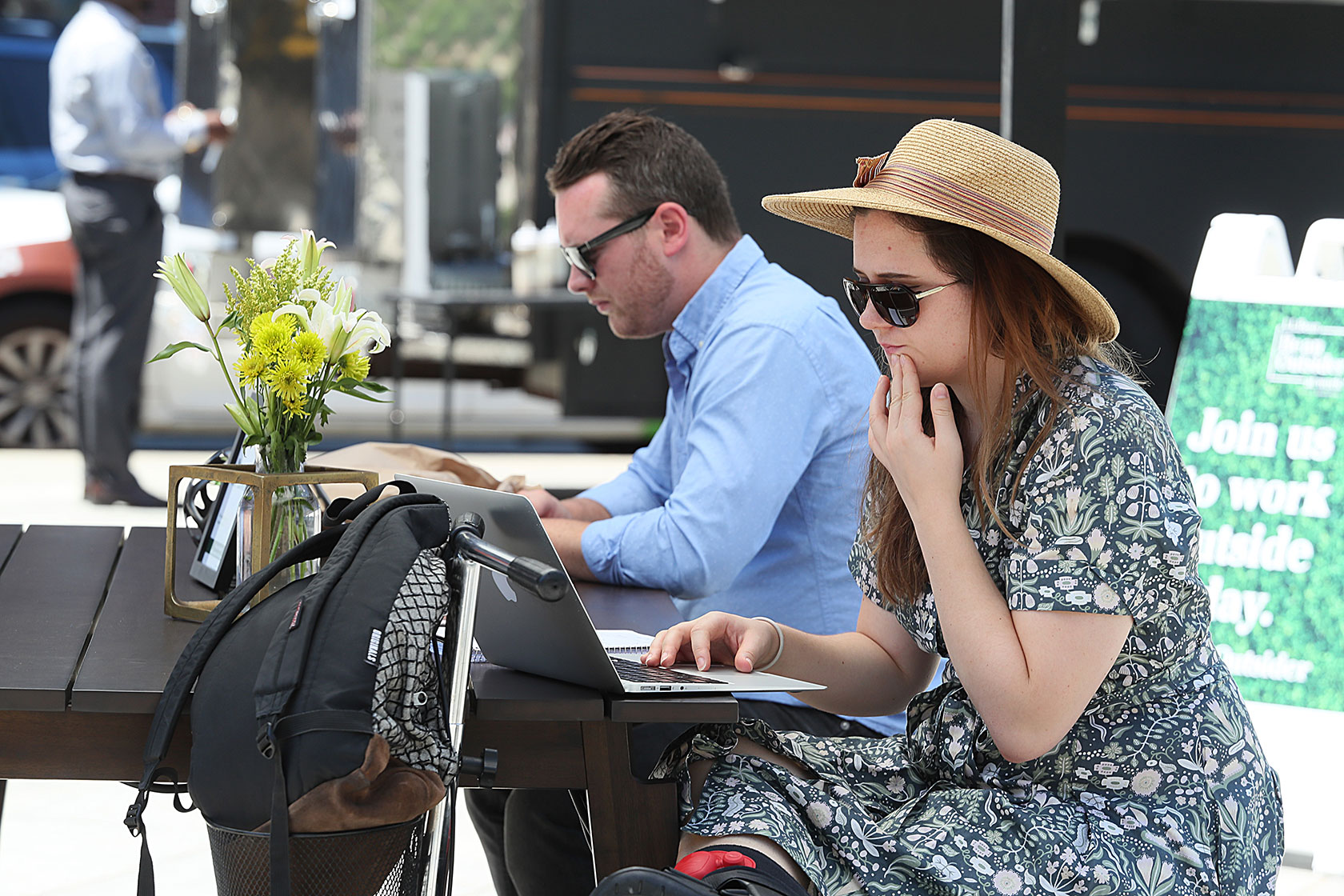 A law student and a self-employed worker use an outdoor coworking space in Boston.
