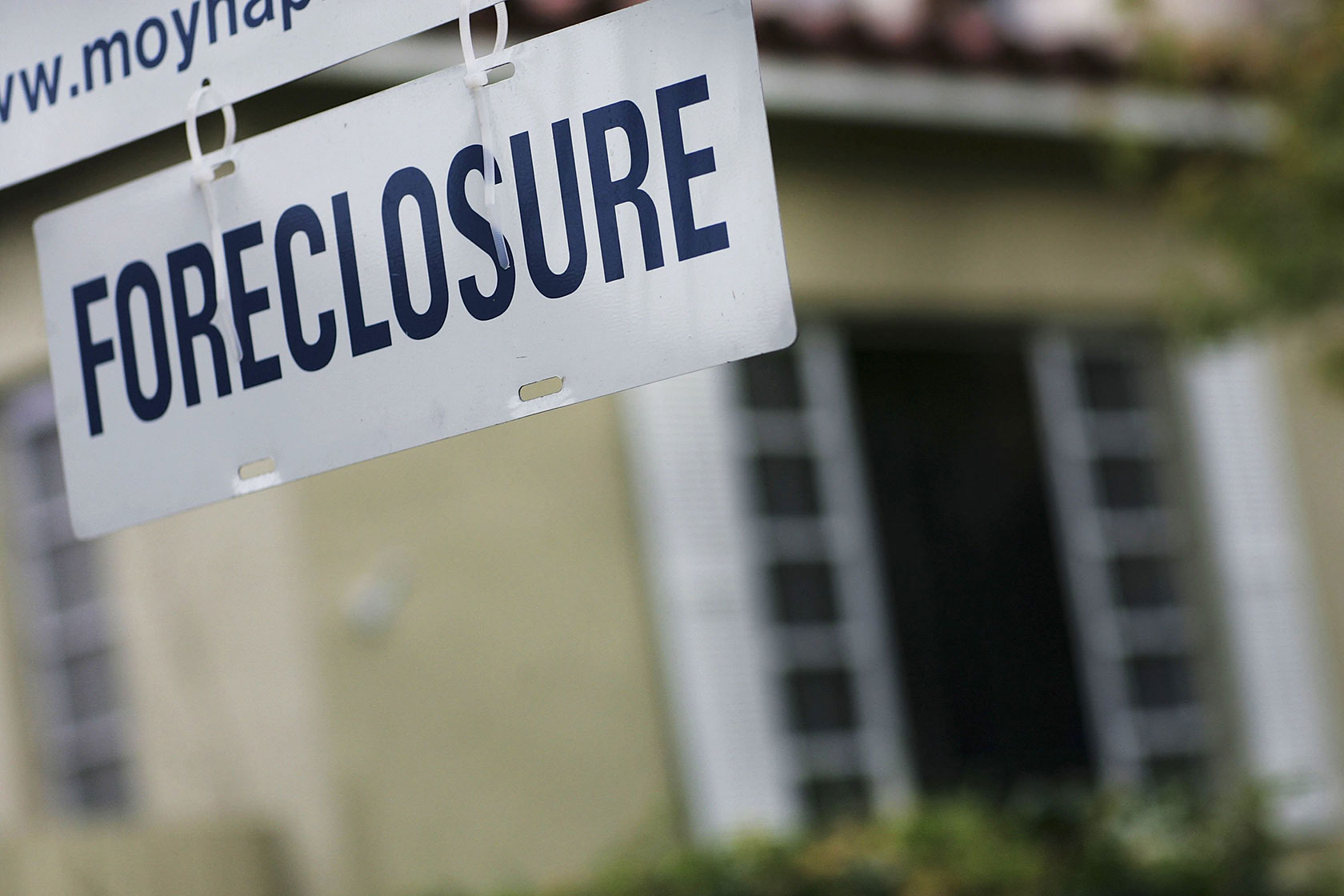 A foreclosure sign hangs in front of a home in Miami.