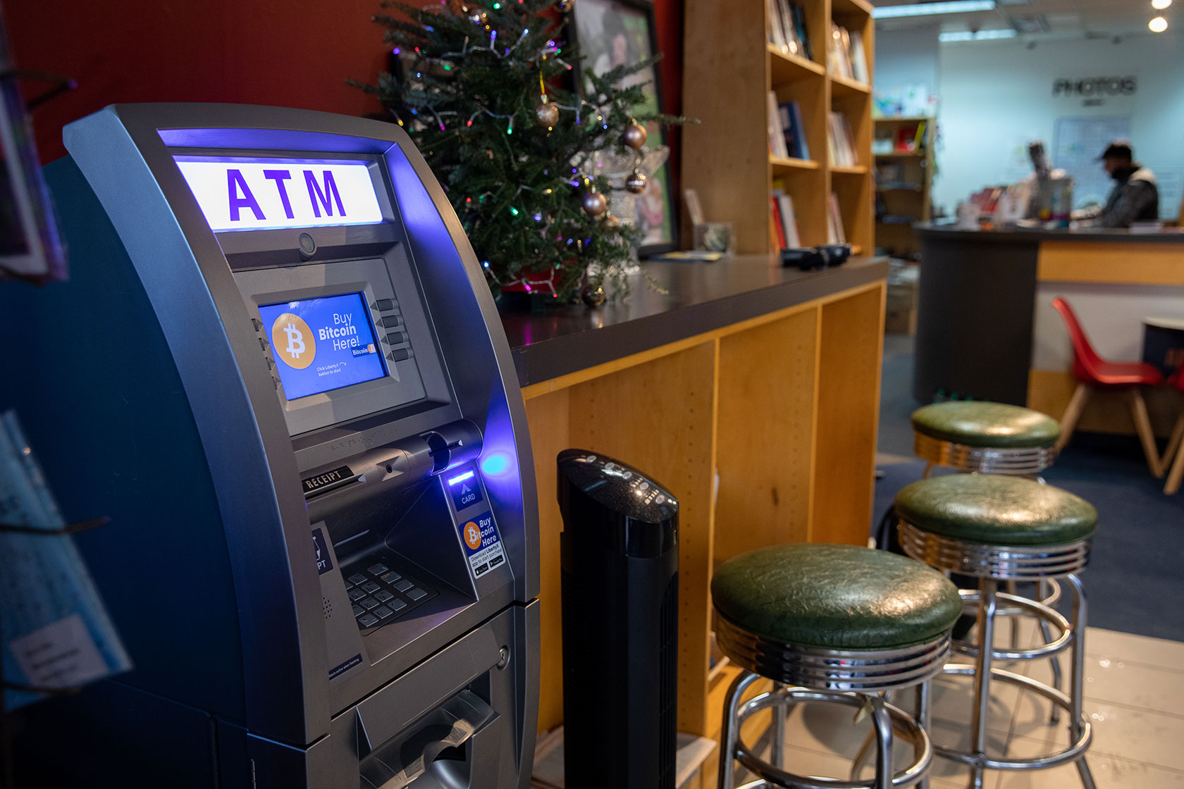 Photo shows an ATM in an empty bookstore with stools nearby