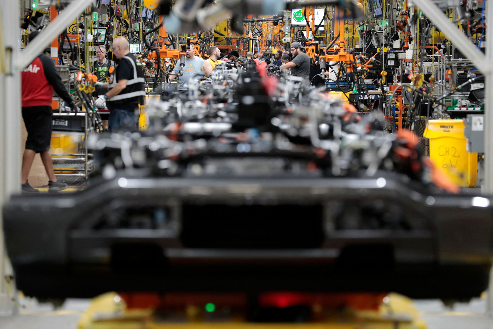 Ford employees work on assembling electric vehicle carp parts.
