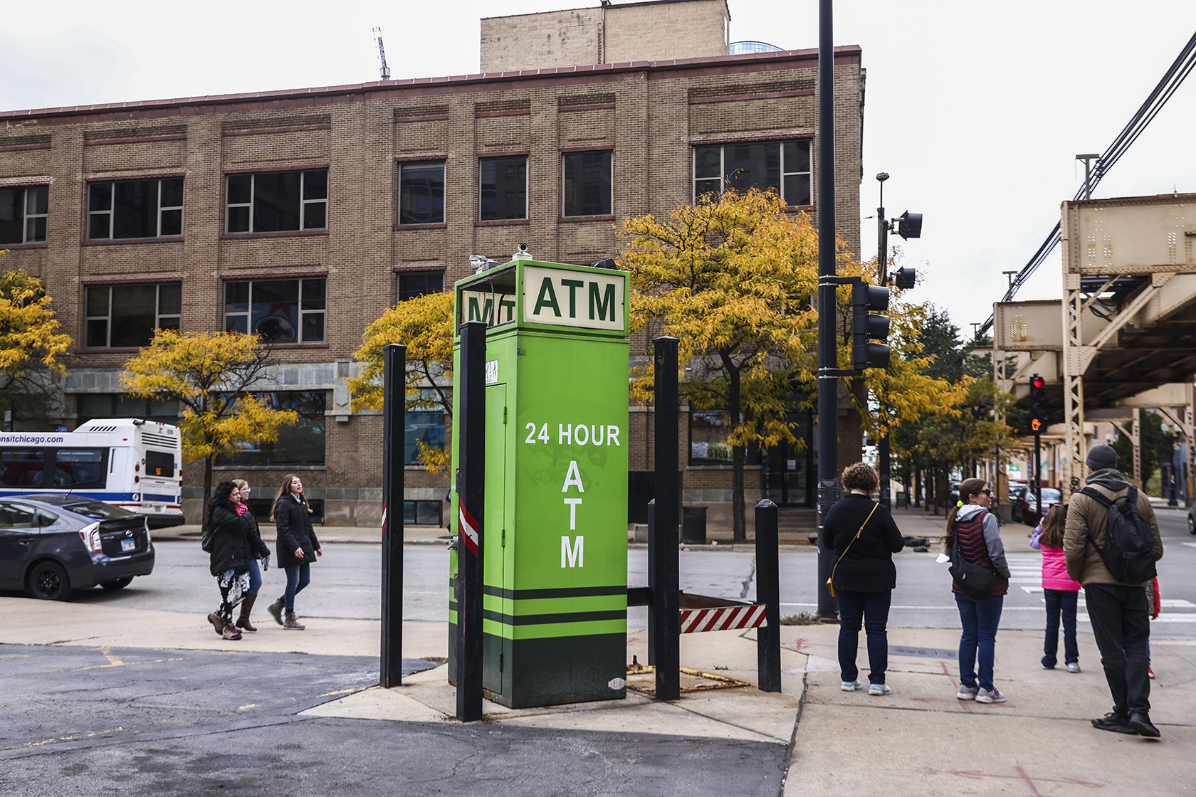 People passing an outdoor ATM