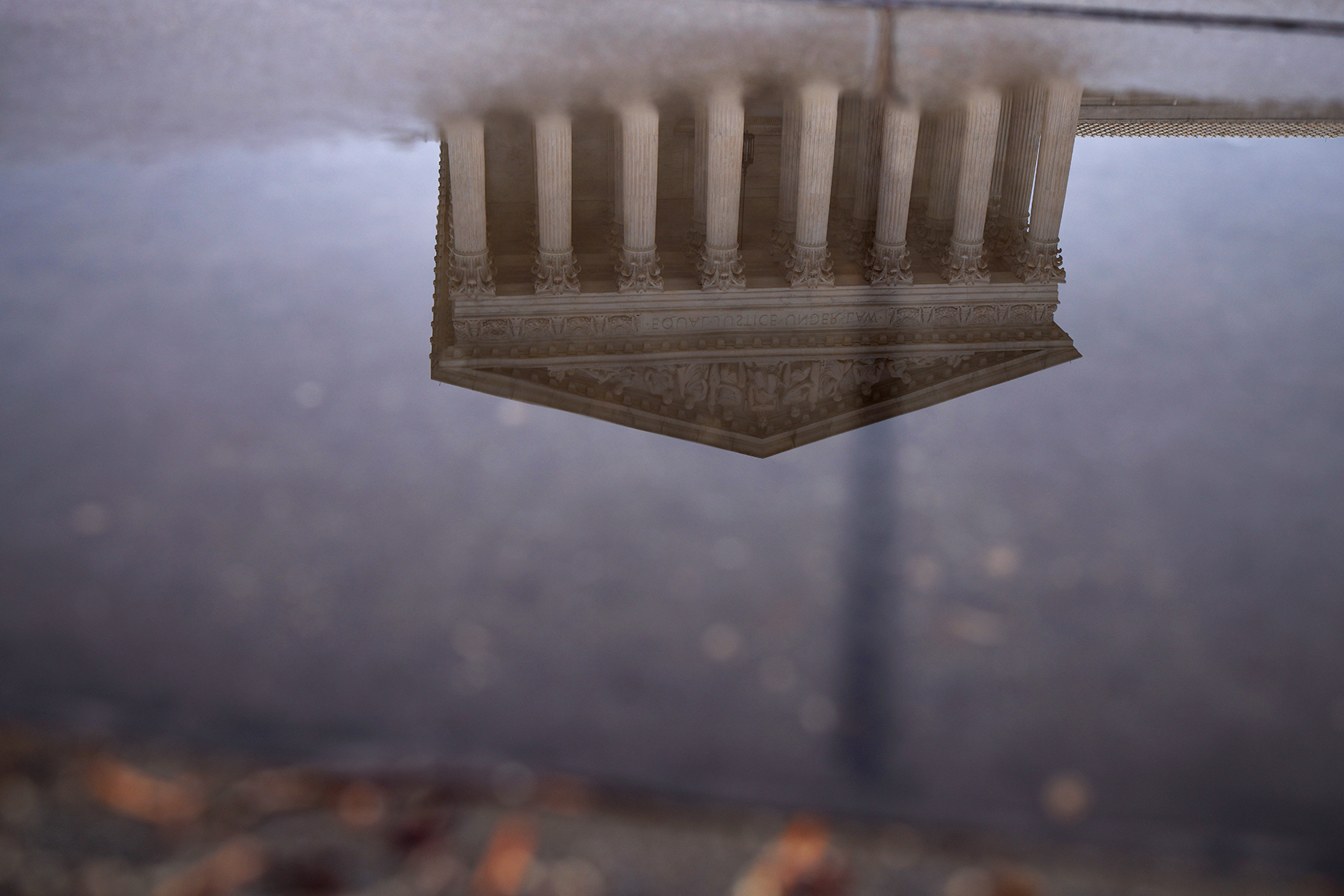 The Supreme Court building reflected upside down in puddle