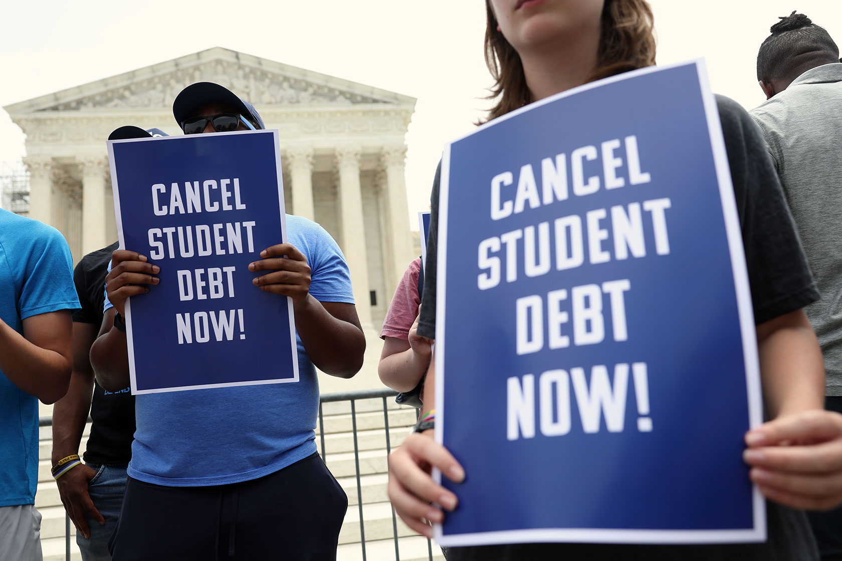 Photo shows two people holding signs that read 