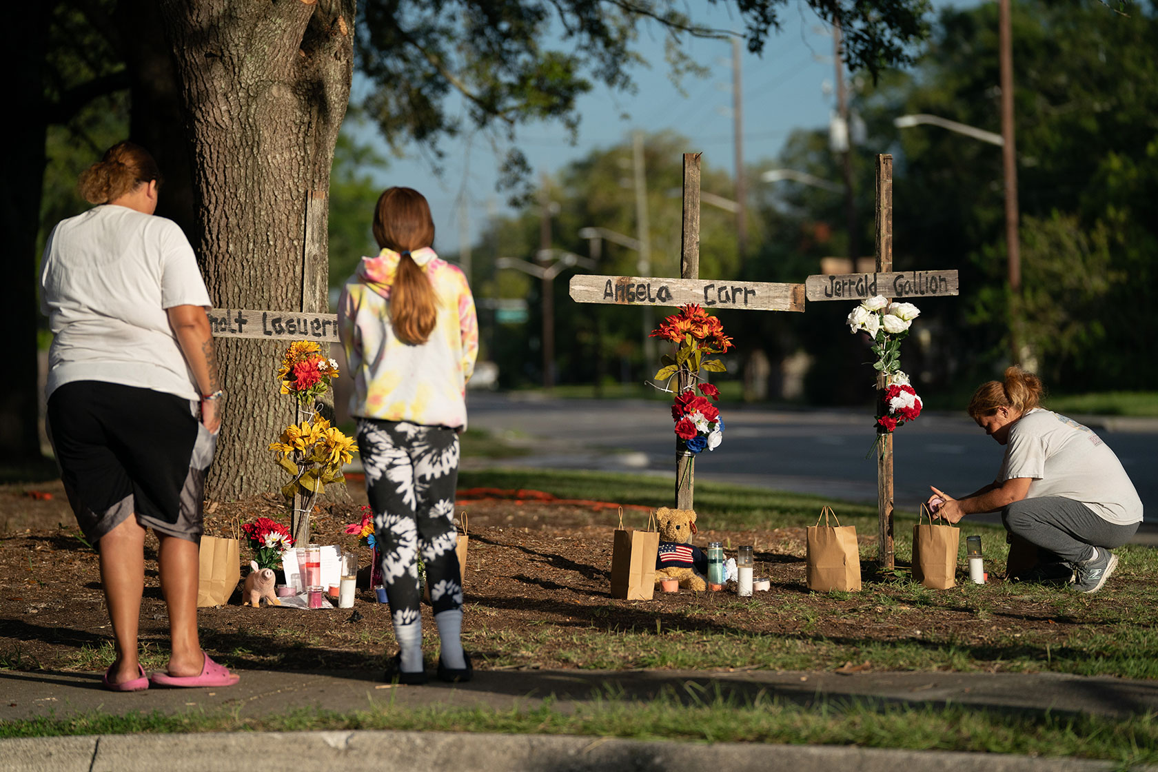 A mother and her daughter visit memorials for Jerrald De'Shaun Gallion, Angela Michelle Carr, and Anolt Joseph “AJ” Laguerre Jr.