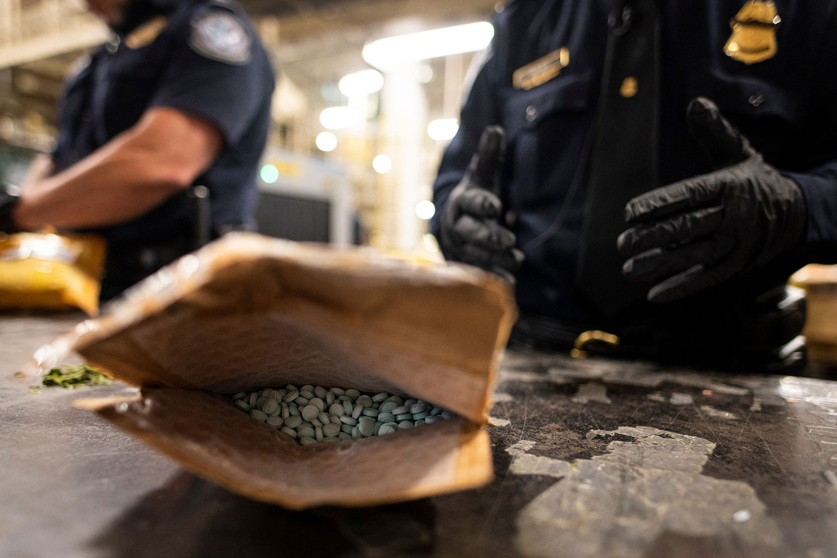 U.S. Customs and Border Protection agents sift through packages in search of fentanyl.