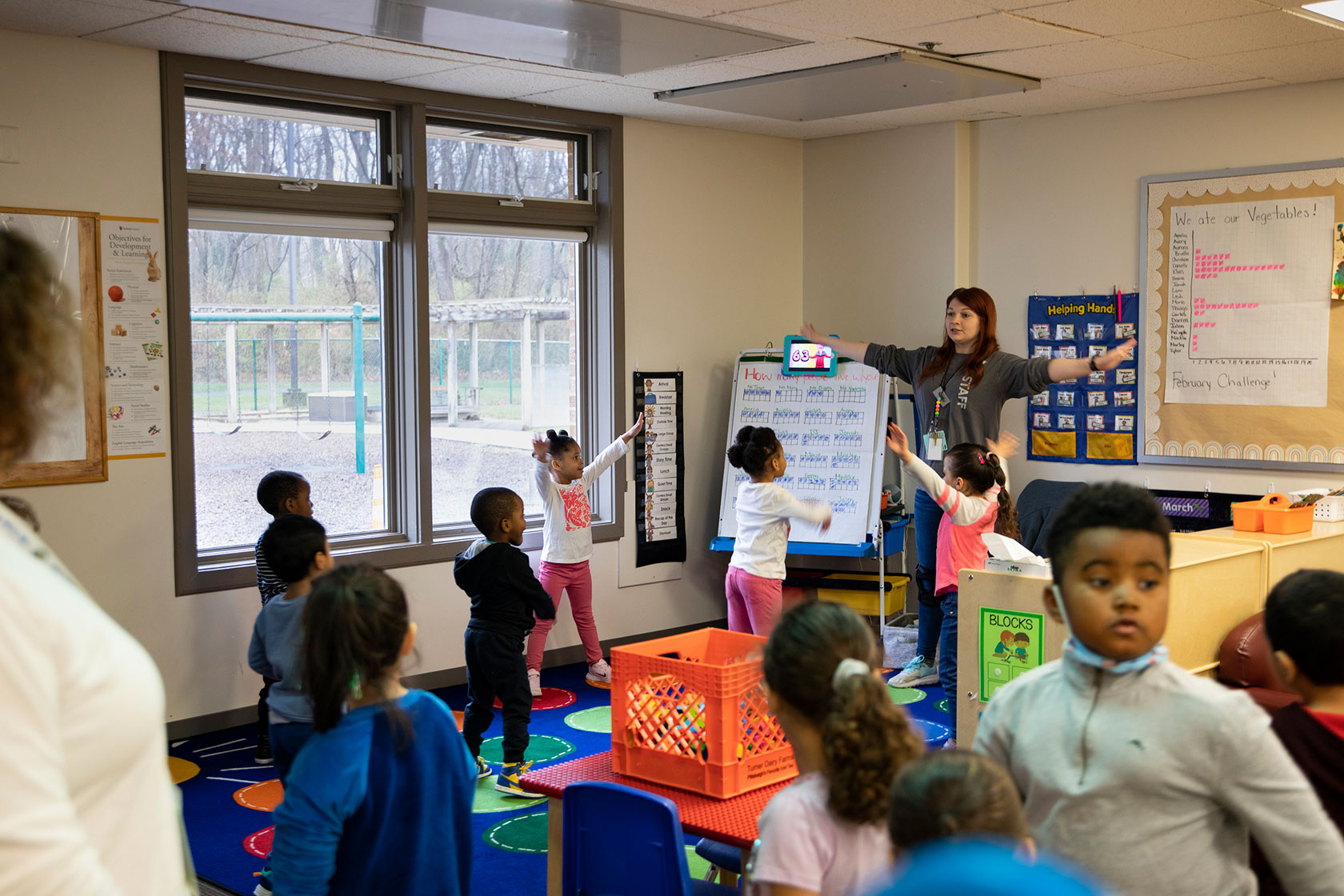 A teacher leads a morning warm-up session for young children in Frederick, Maryland.
