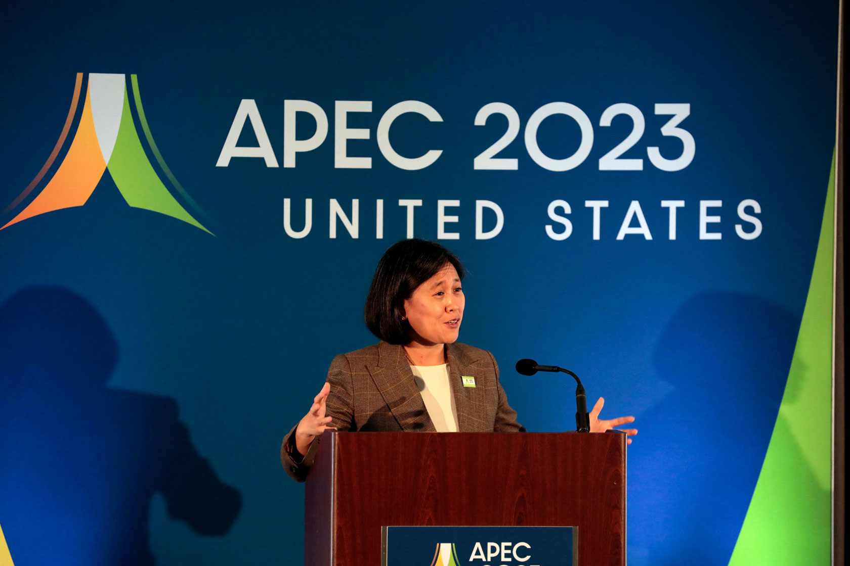 Ambassador Katherine Tai stands at a podium delivering remarks before a sign that reads, “APEC 2023: United States.” Caption: Ambassador Katherine Tai delivers remarks at an Asia-Pacific Economic Cooperation meeting in Detroit on May 26, 2023. (Getty/AFP/Jeff Kowalsky)