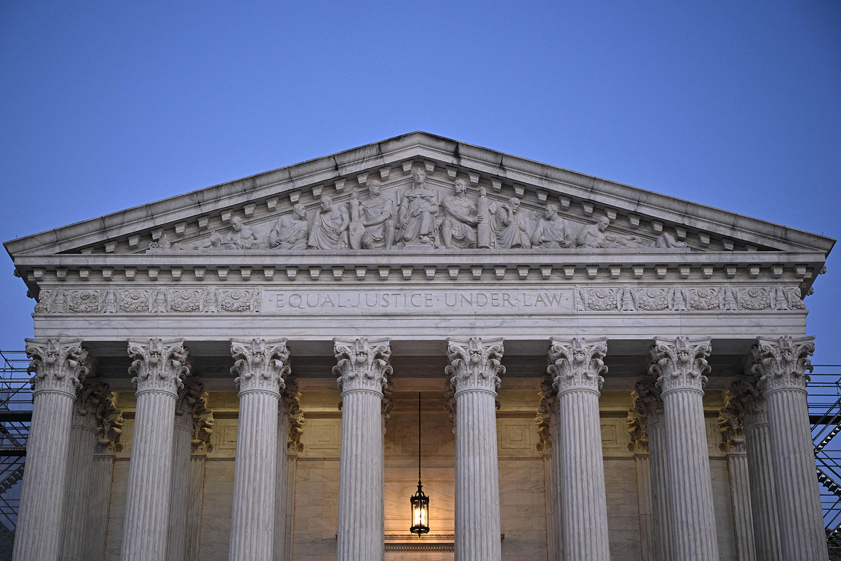 Photo shows the front of the Supreme Court building against a dusky blue sky