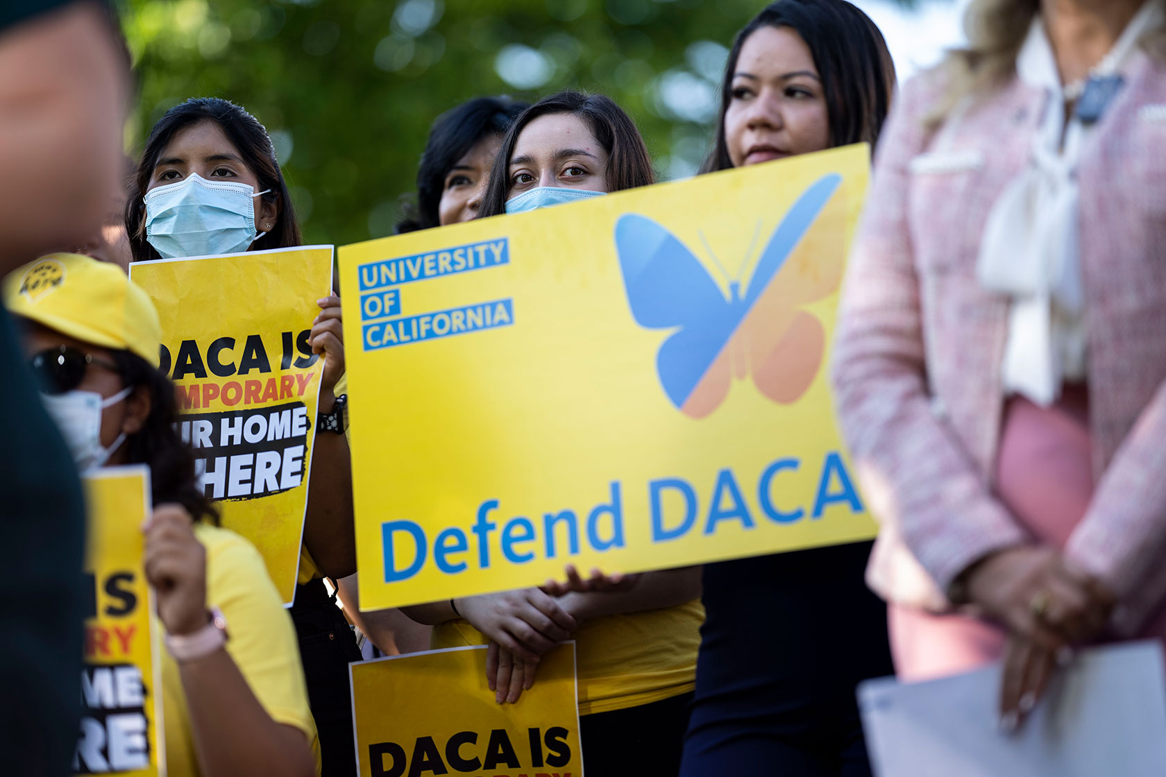 Activists listen during a news conference marking the 10th anniversary of DACA