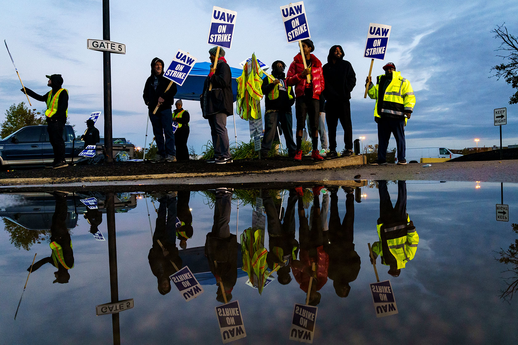 Factory workers and UAW union members form a picket line.