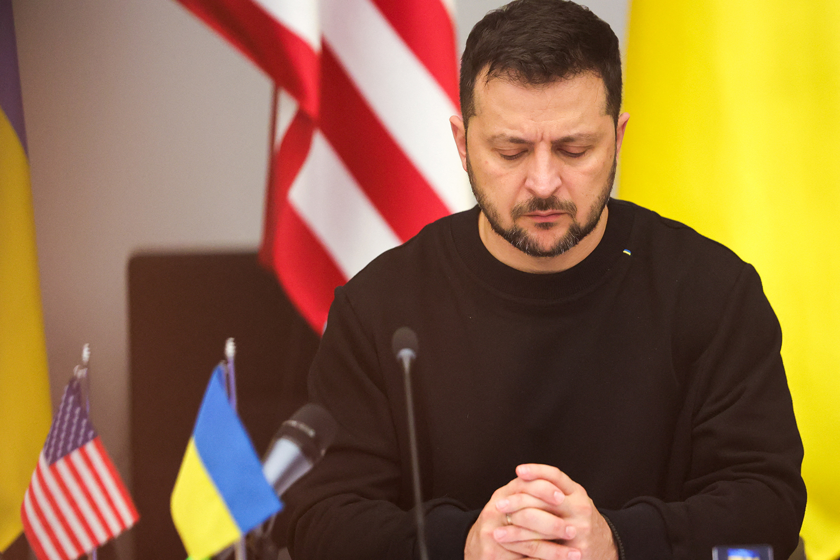 Volodymyr Zelenskyy beside Ukrainian and American flags