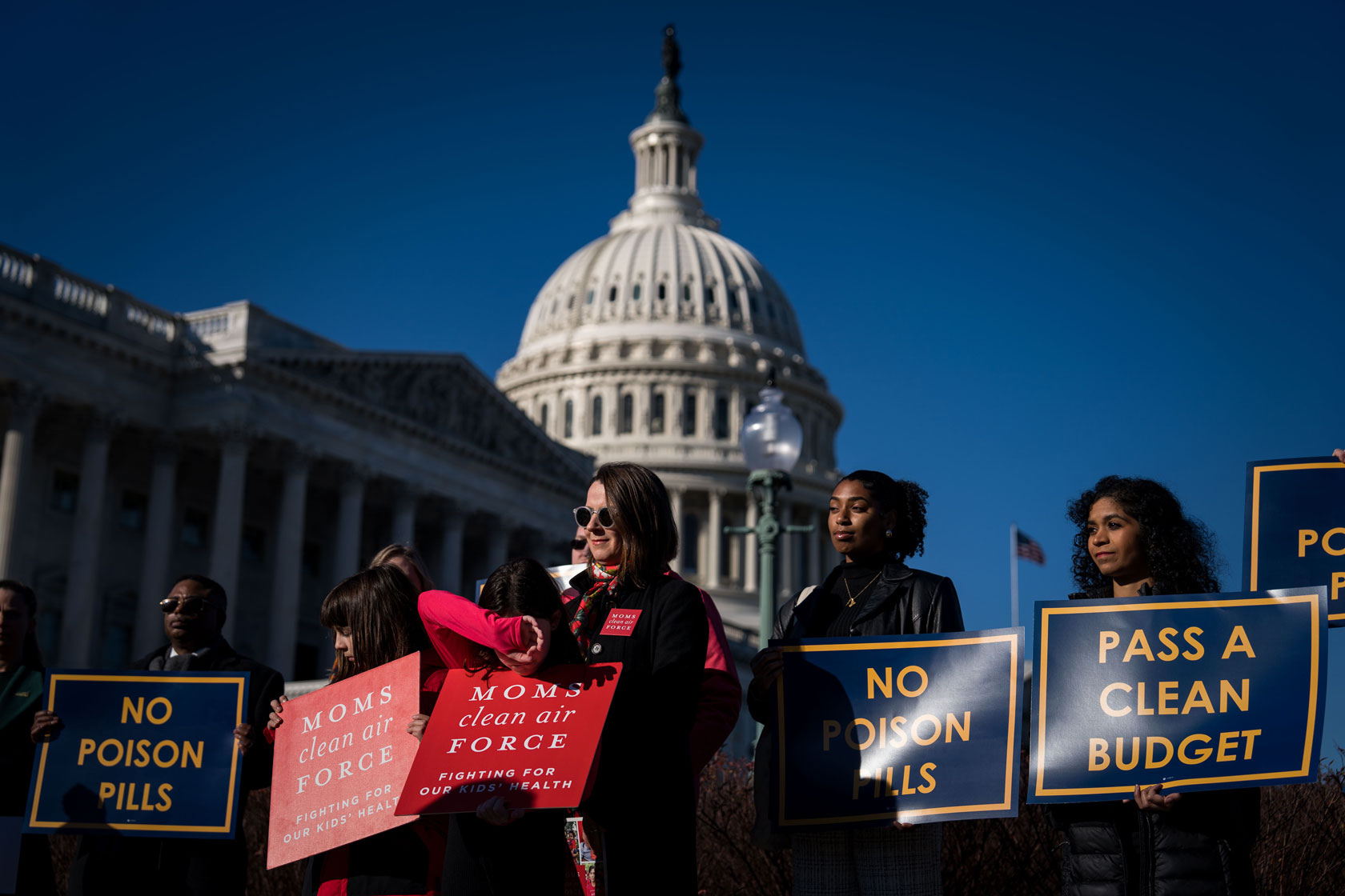 A group of people is seen holding signs outside of the U.S. Capitol building.