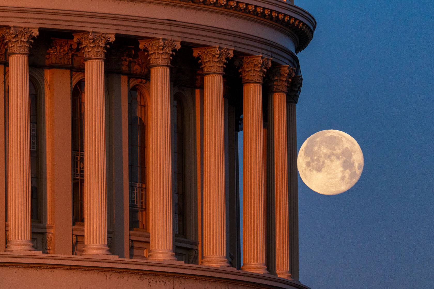 The waning Snow Moon sets behind the U.S. Capitol Dome.