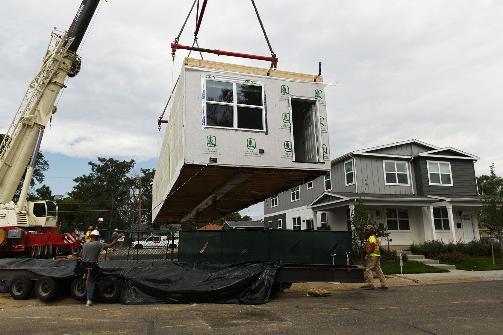 A crane stacks modular home segments to make a new duplex.