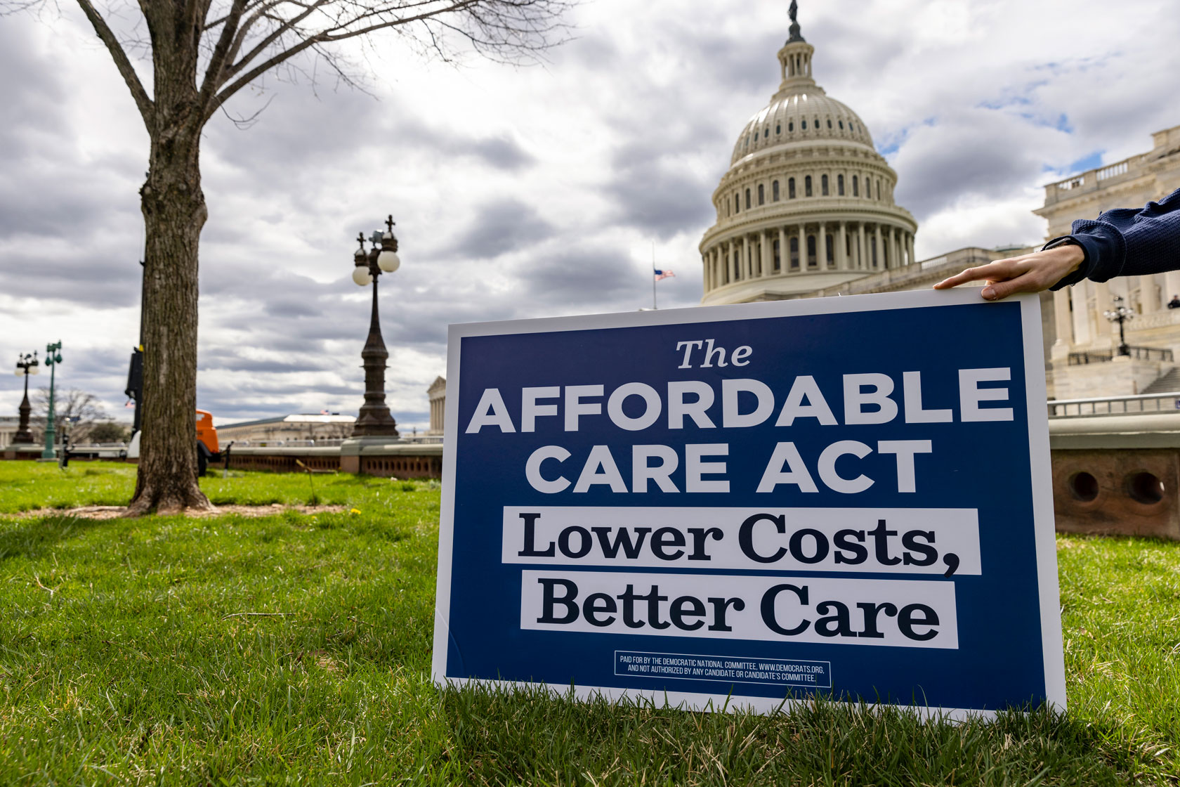 A sign demonstrating support of the Affordable Care Act is seen on a patch of grass in front of the U.S. Capitol building.