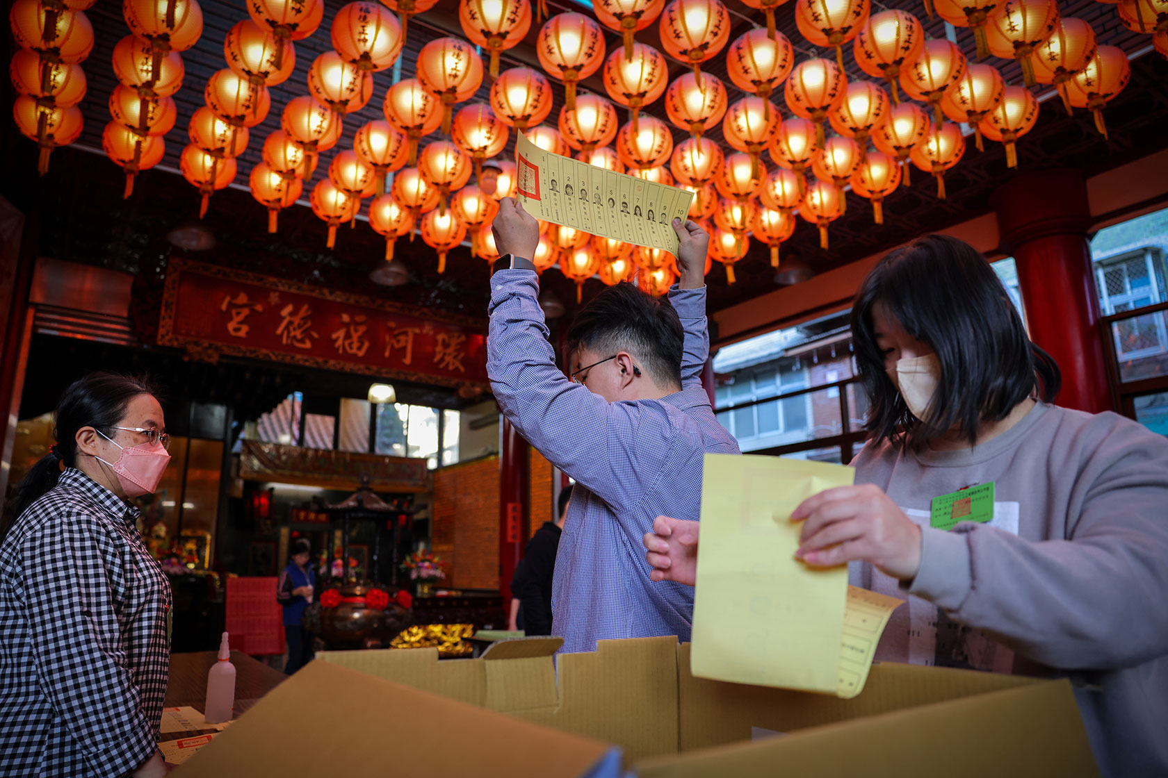 An election worker holds up a ballot as the official counting gets underway.