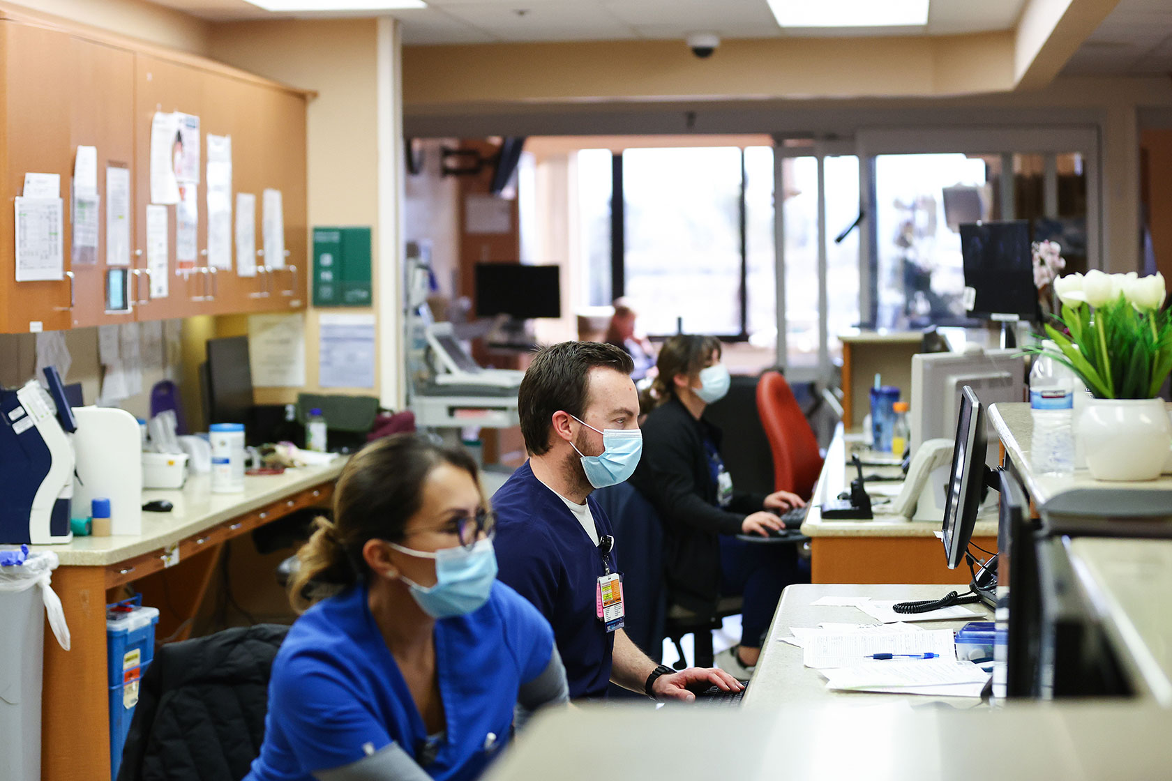 Registered nurses sit at their desks while working at a medical center.