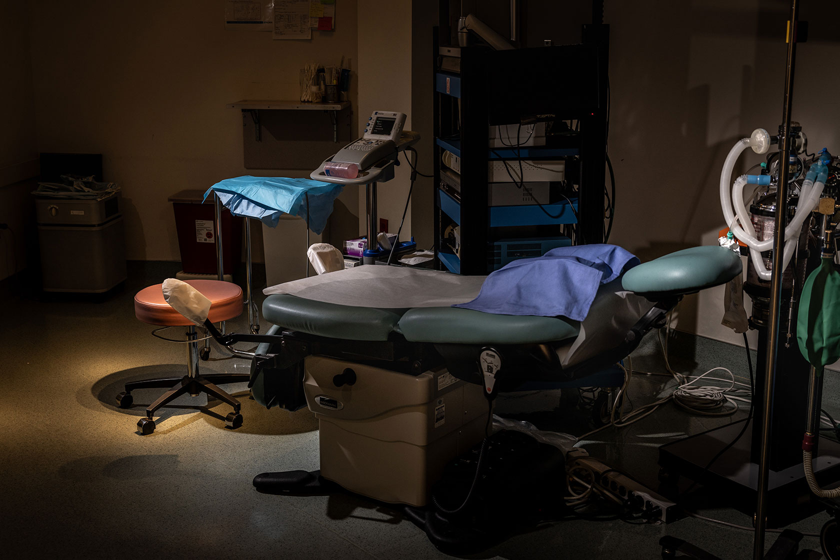 Photo shows equipment and a bed in a procedure room with dim lighting